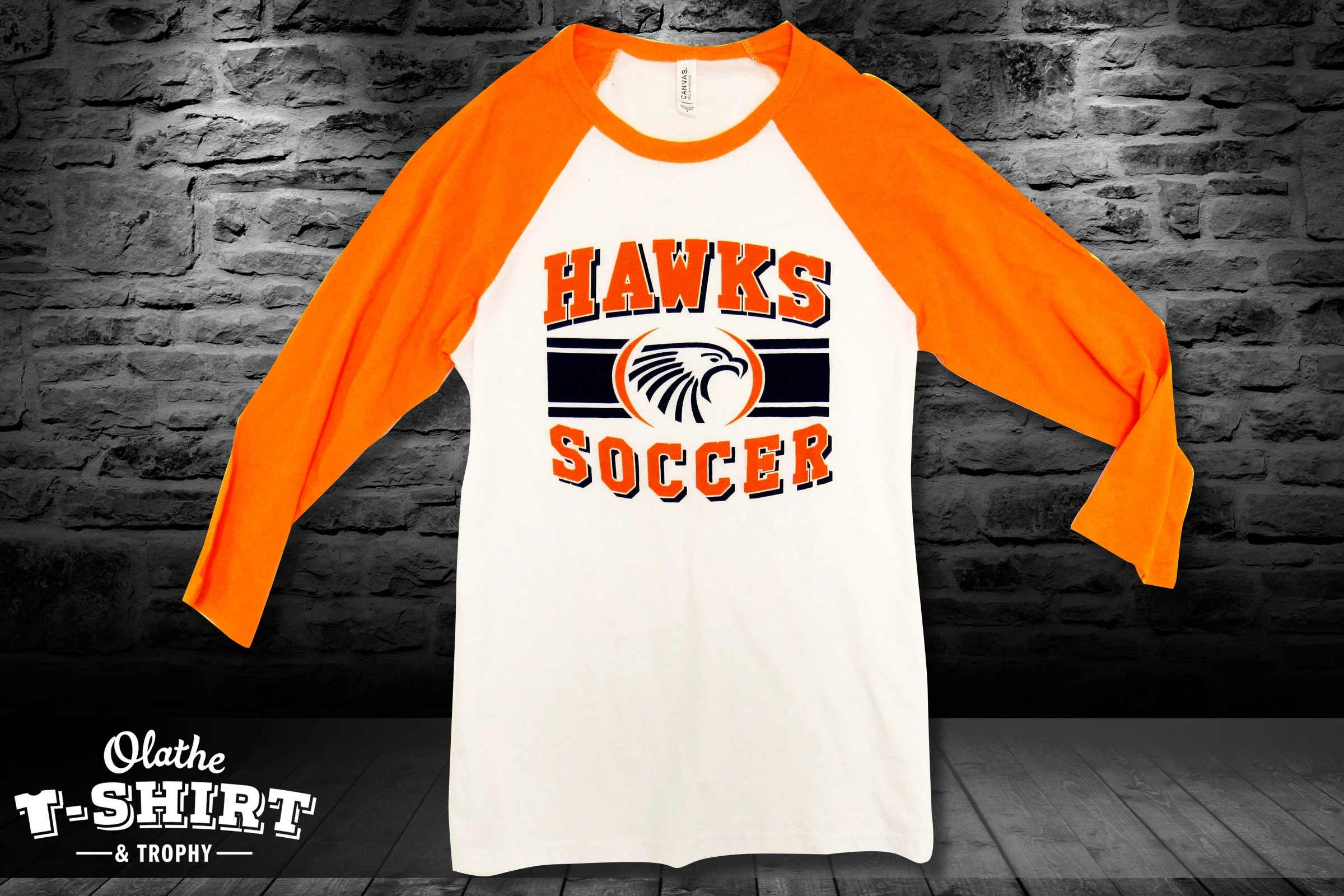 Navy Olathe East Hawks Soccer shirts showing two coordinating logo designs.