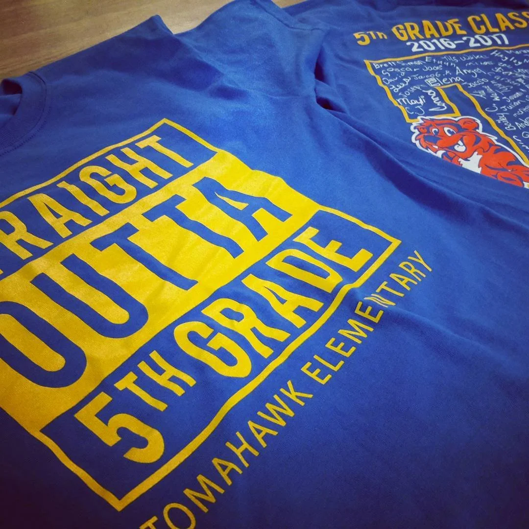 Blue fifth-grade school shirt with yellow and purple lettering and a tiger mascot.