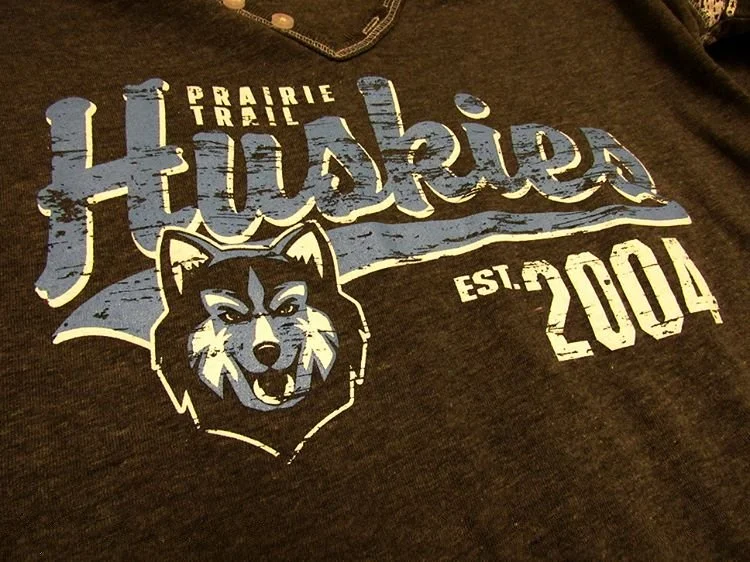 Close-up of blue and white school graphics printed on black fabric.