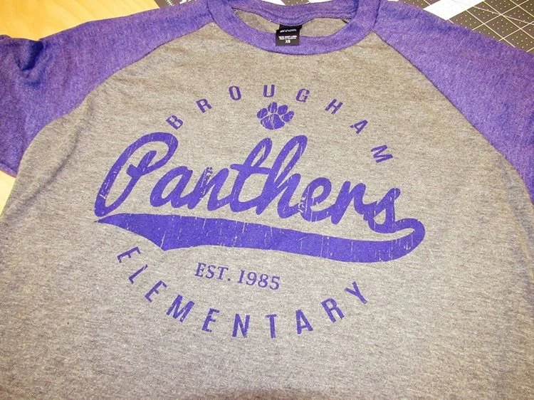 Gray and purple Brougham Panthers baseball-style shirt with a paw-print design.
