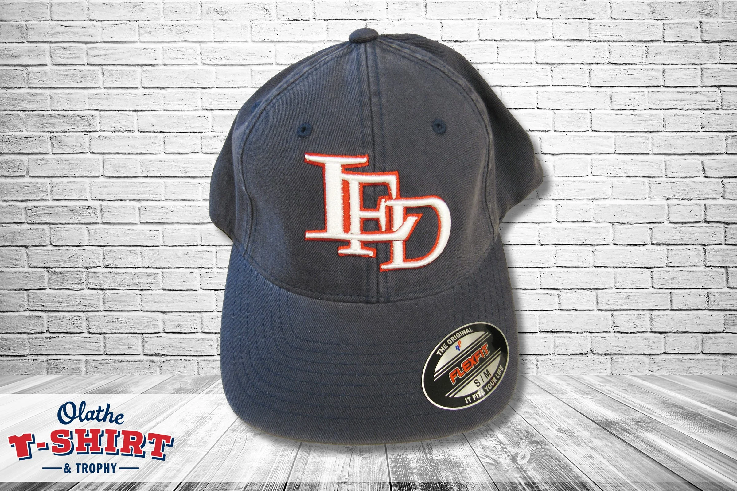 Navy cap with red and white embroidered initials.