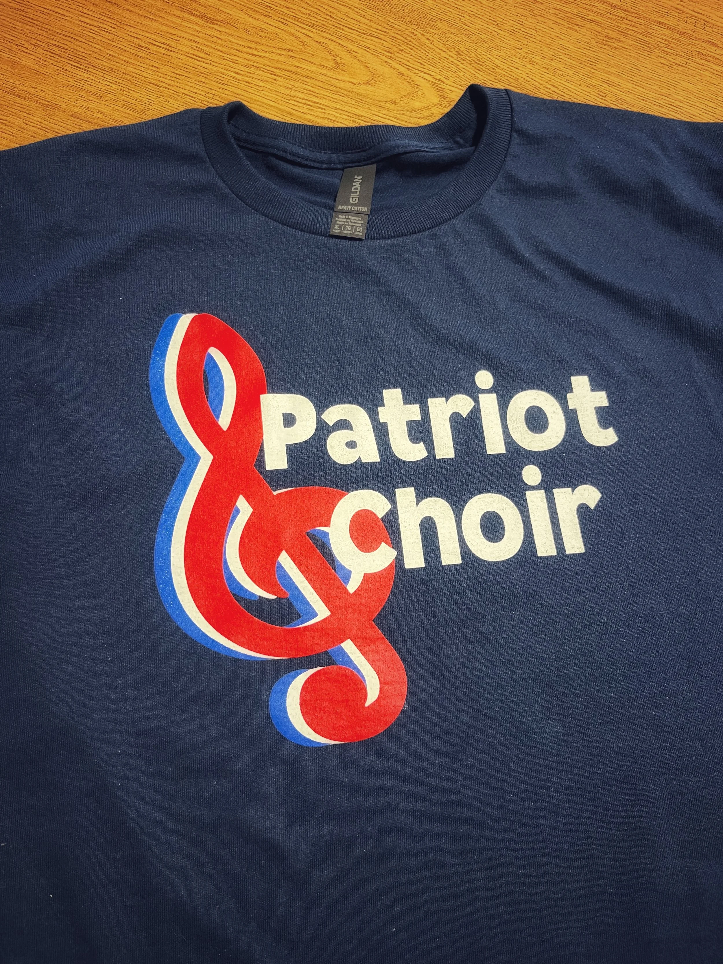 Navy T-shirt with a red, white and blue ribbon design and lettering.