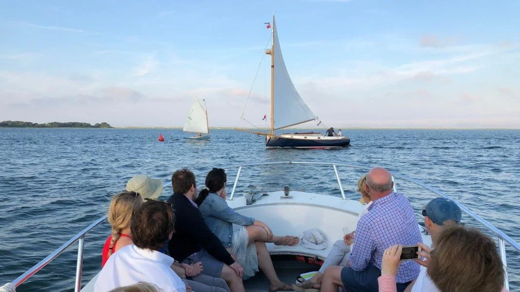 Guests on a boat cruise viewing a cat cboat sailing along