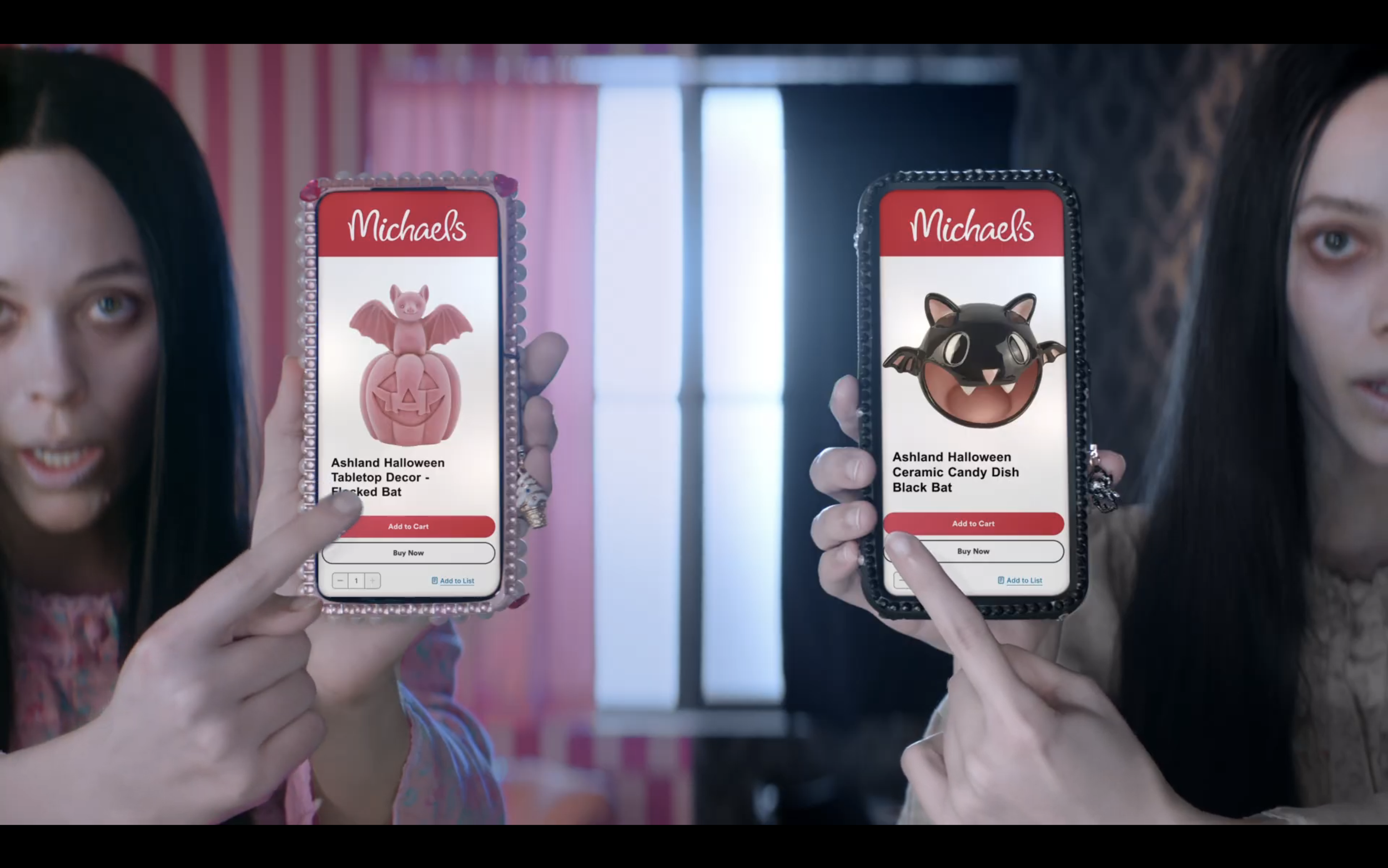 Two women showcasing Halloween-themed products on their smartphones, including a pink bat figurine in a pumpkin and a black bat figurine.