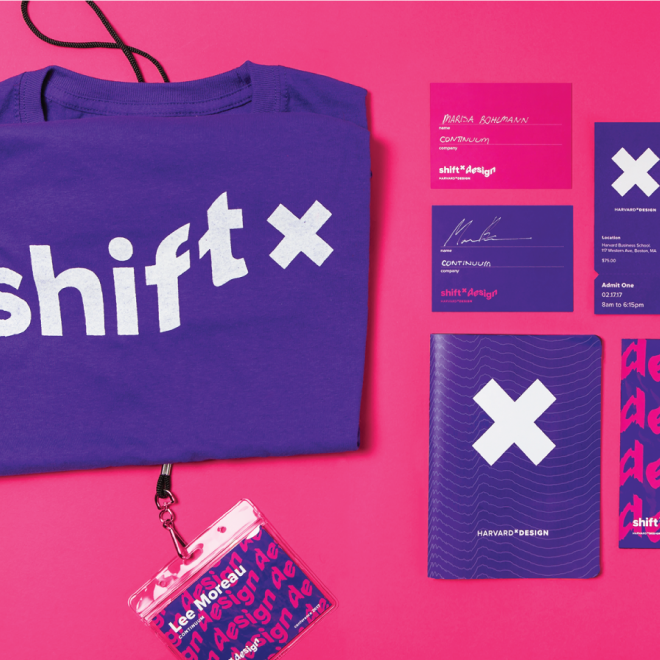 Harvard + Design conference materials including a purple shirt with 'shift x', name tags, a blue notebook with a white 'x', and a clear badge holder with an ID badge, all laid out on a pink background.