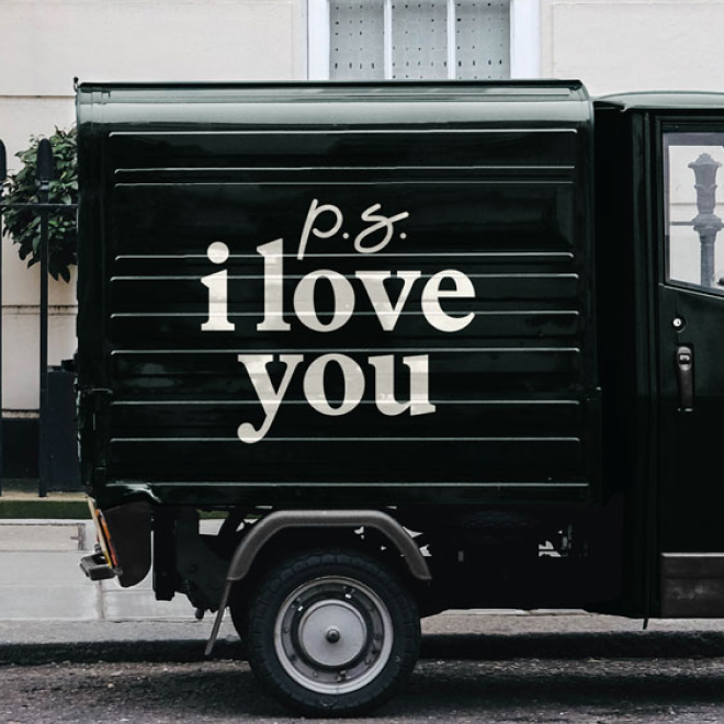 The side of a black delivery truck with white text that reads, "p.s. i love you."