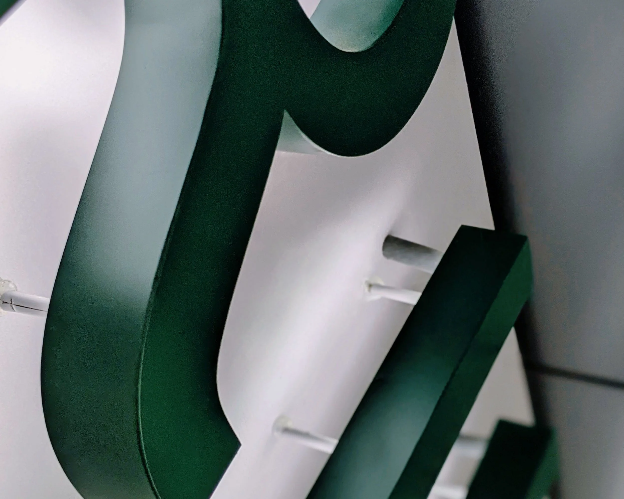 Close-up of a green lettered, backlit sign