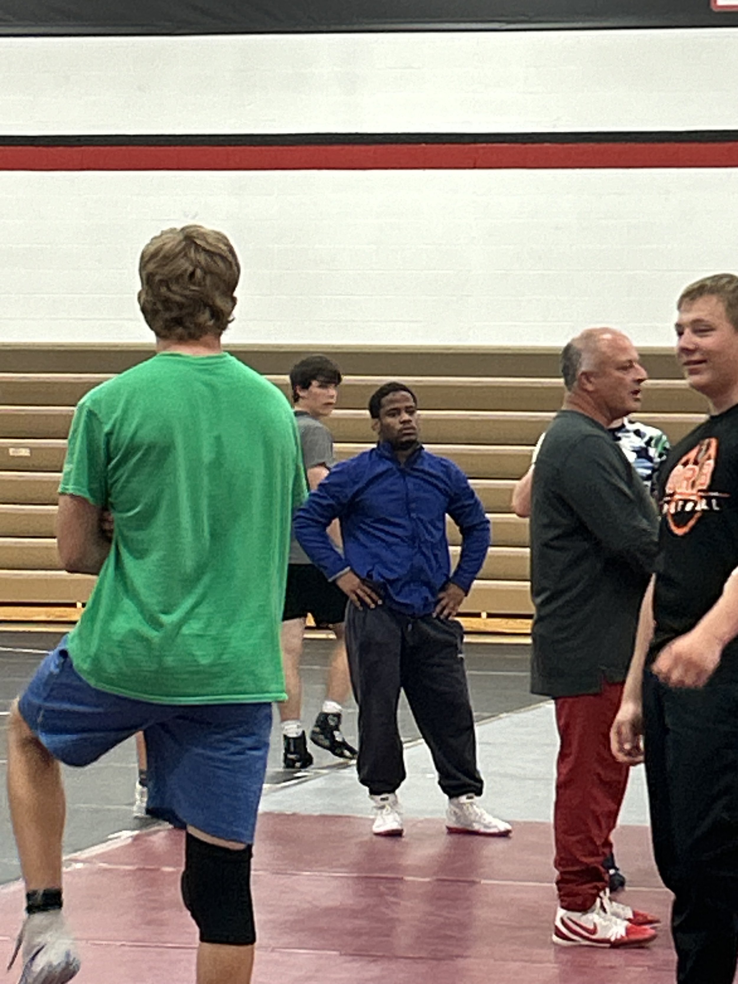 Scenic landscape with a mountain range, lush hills, and a clear, blue lake under a cloudy sky.