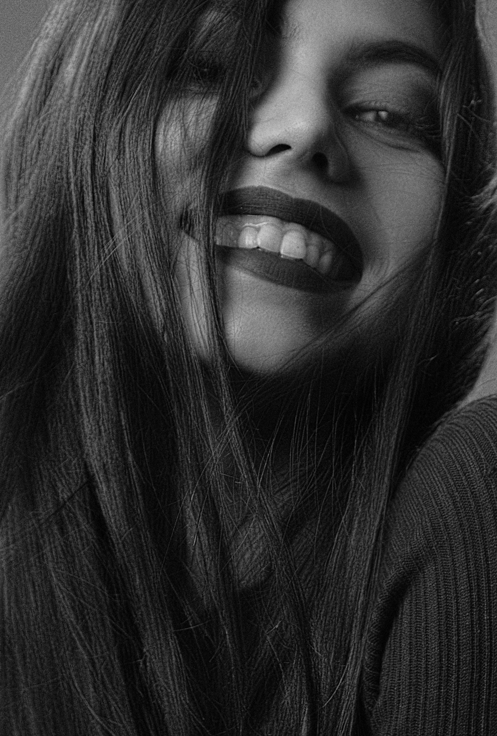 greyscale photo of woman with forced smile | trauma therapy in pittsburgh philadelphia memphis nashville
