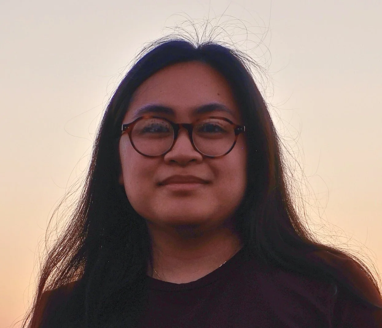 woman with dark hair and glasses smiling in sunset | chelsea adams | therapist for depression in reading pa