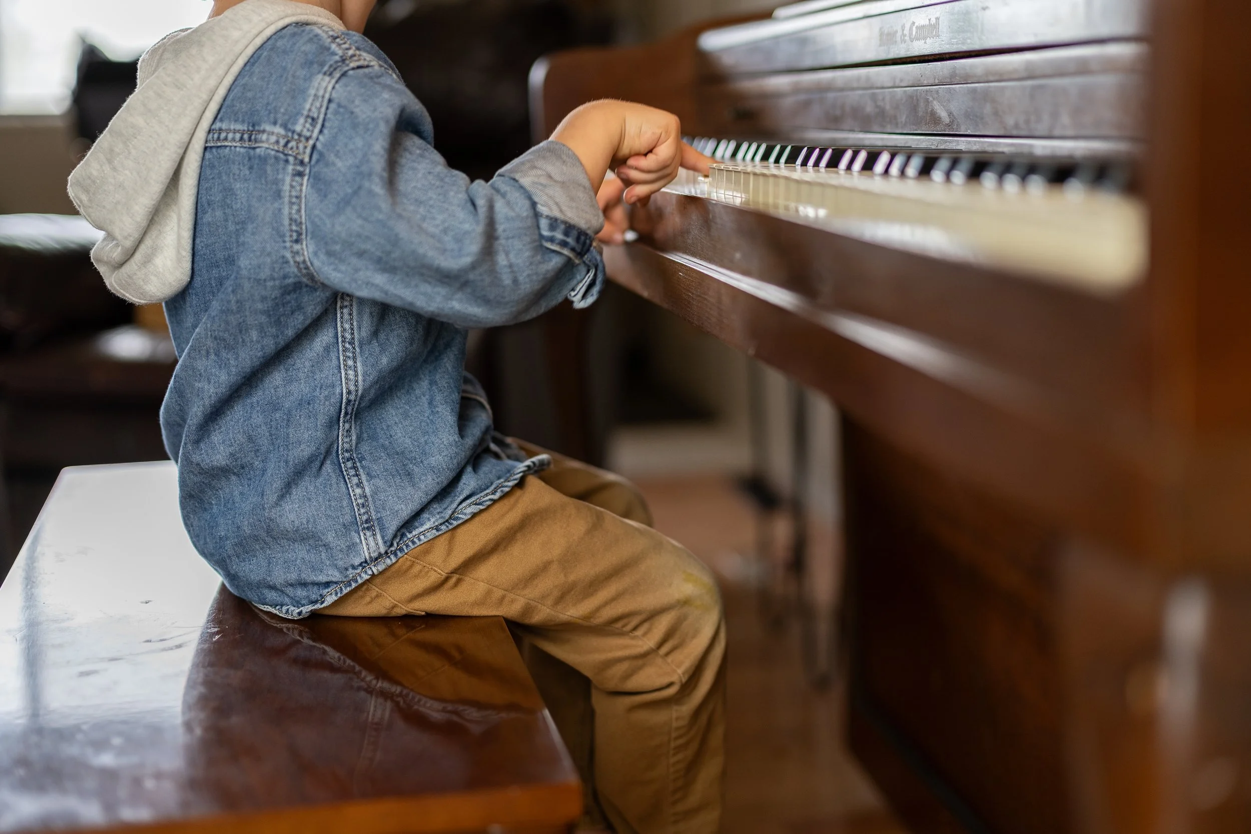 Young boy playing the piano at home, enjoying music in a peaceful family environment that encourages creativity and joyful learning.
