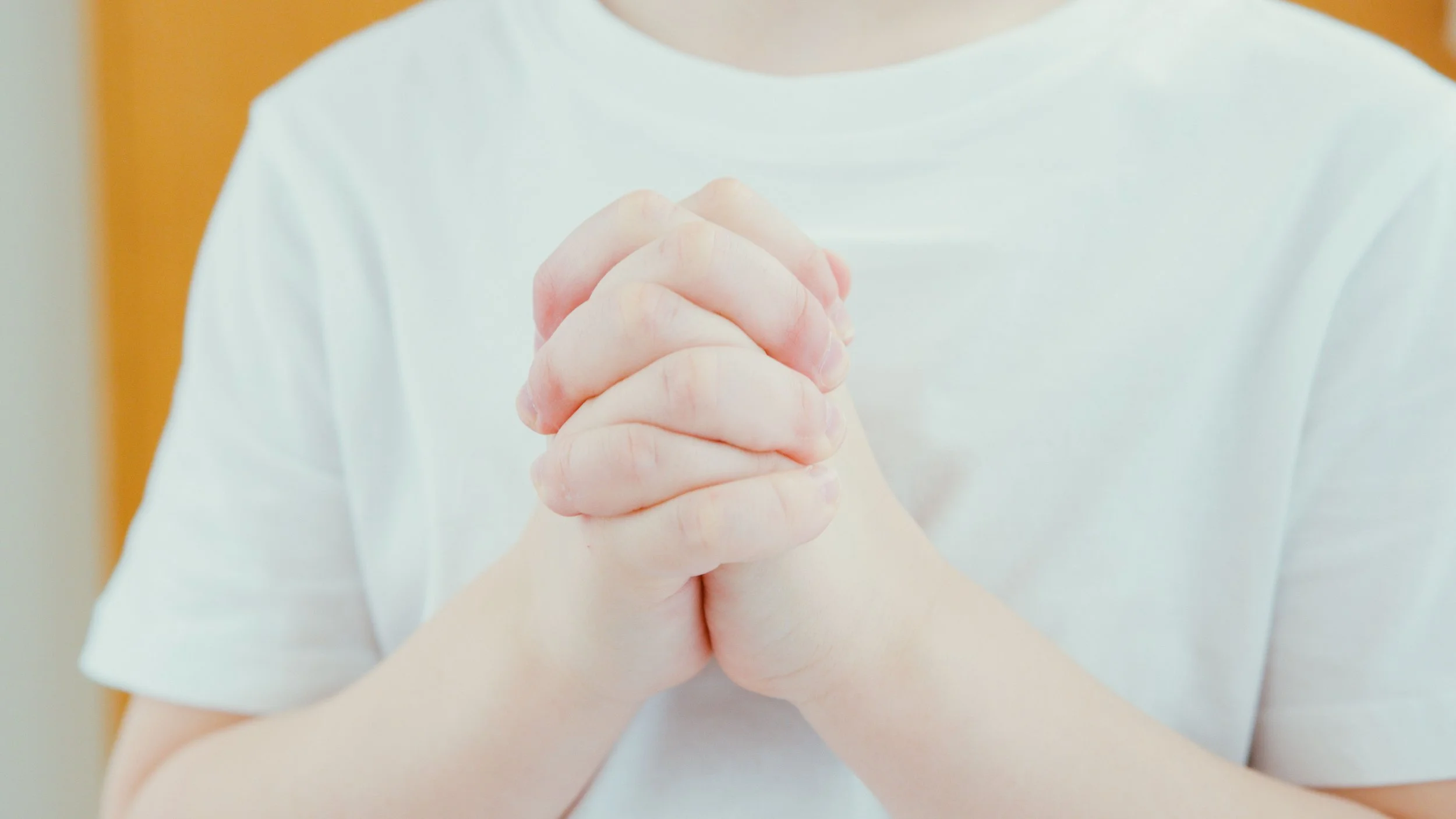 Young child praying quietly before bedtime, learning to talk with God through simple daily prayer.