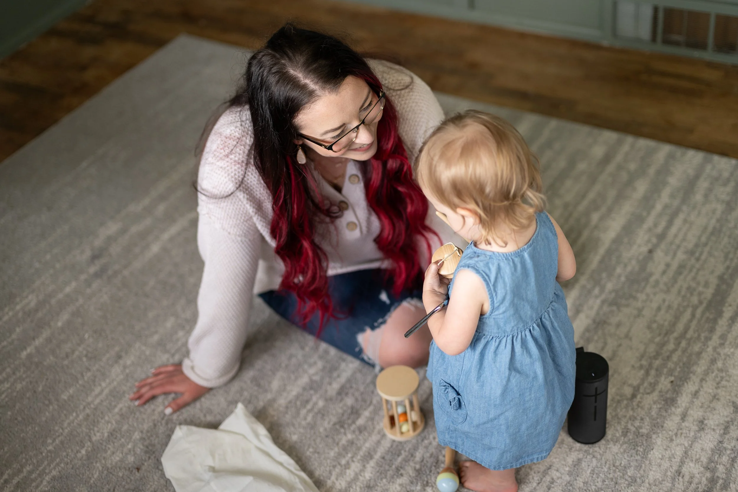 Mother and daughter smiling while playing with musical toys together, enjoying music and creating joyful moments during everyday family life.