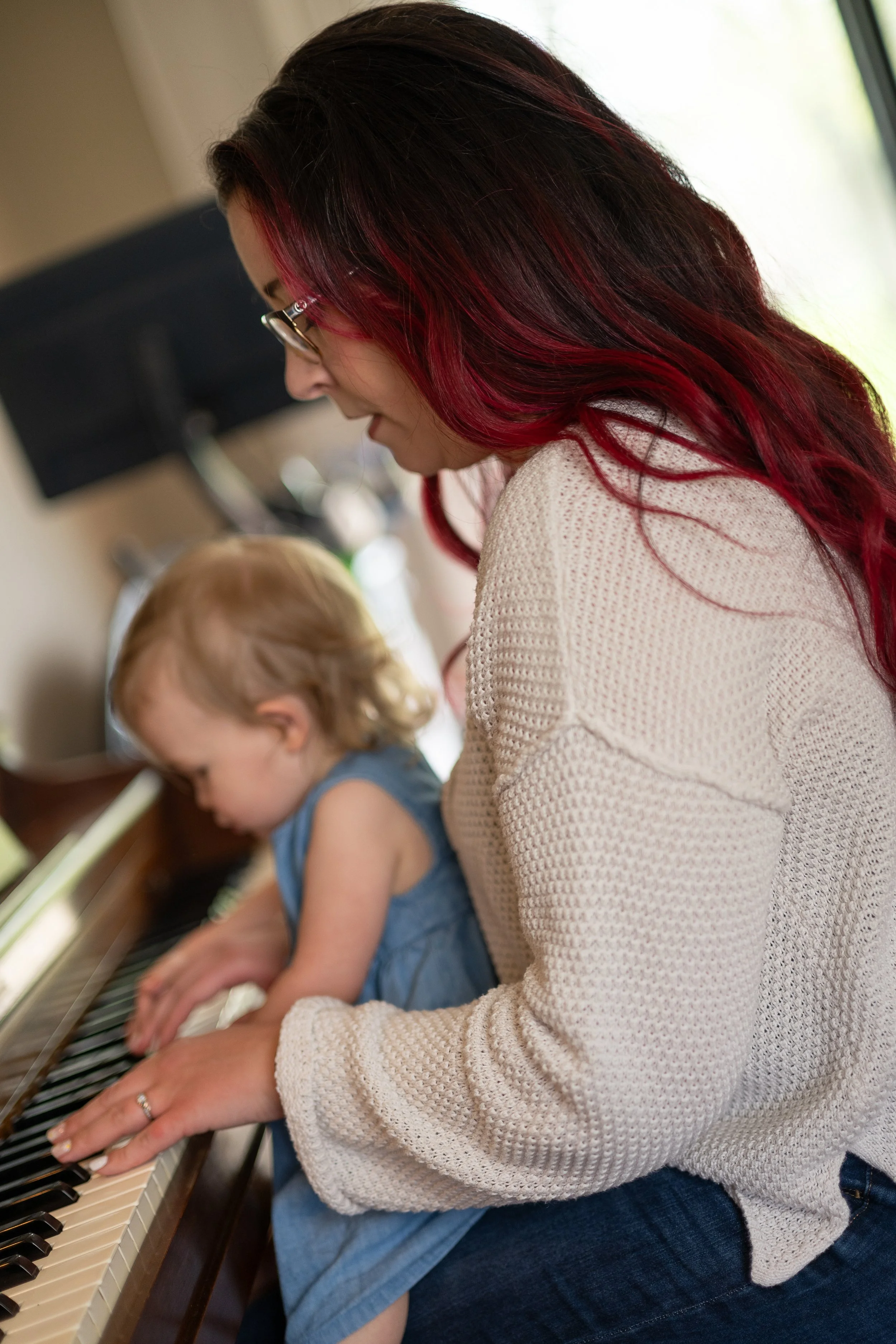 Mom and baby at piano playing Christian worship music in a peaceful home