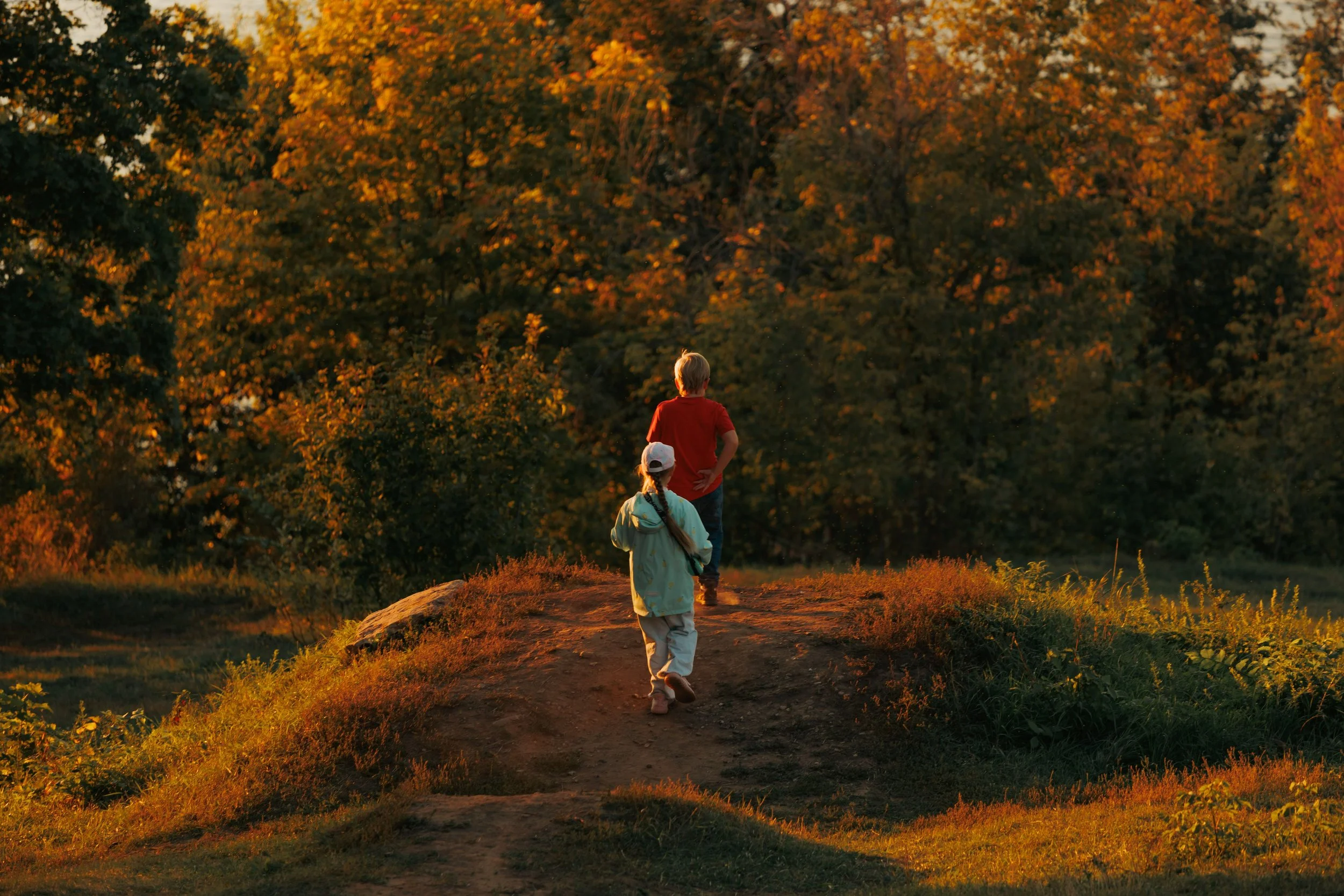 Family walking together outdoors and enjoying the colorful fall leaves.