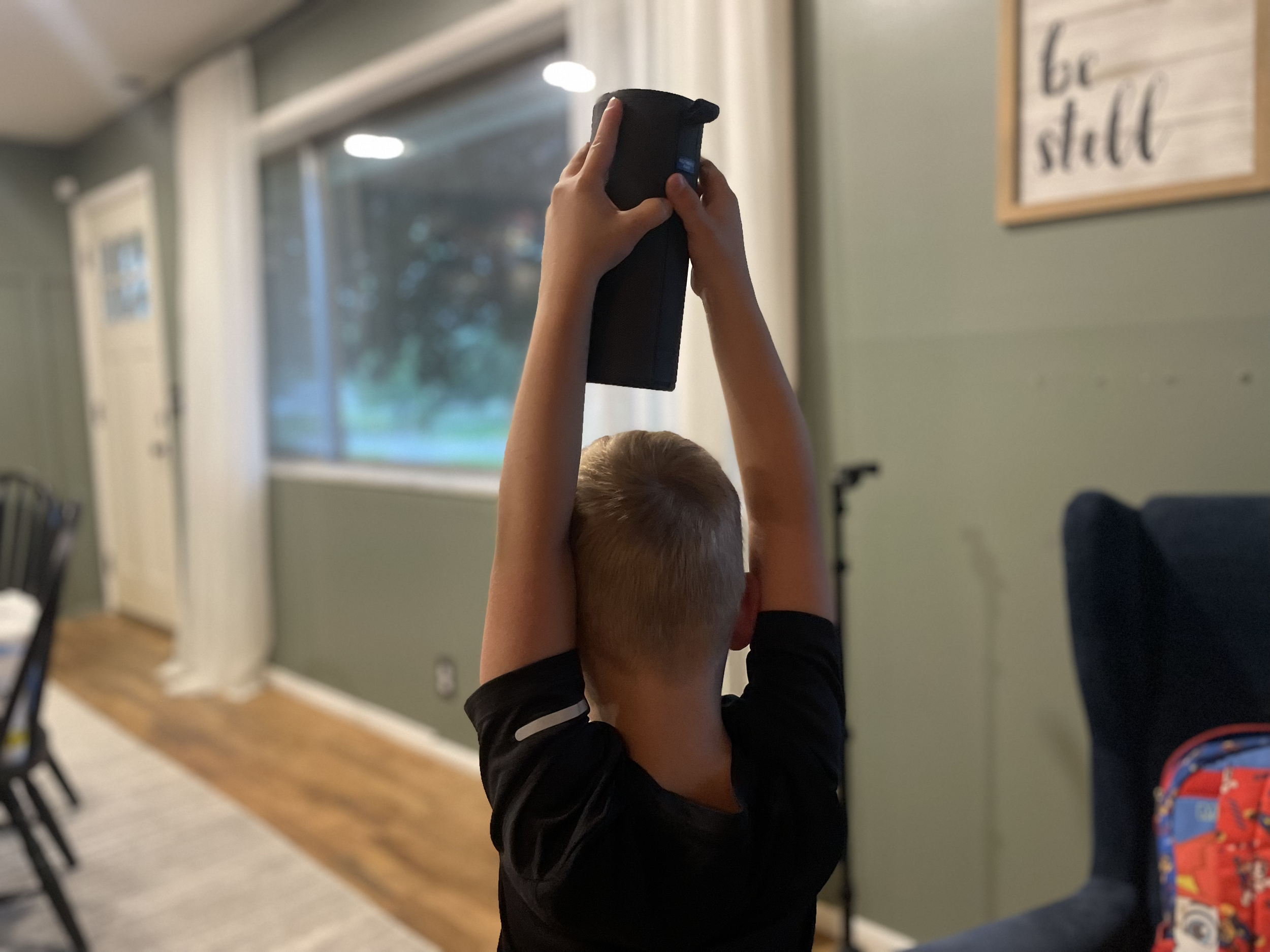 Son worshipping enjoying peaceful family rhythms using a bluetooth speaker