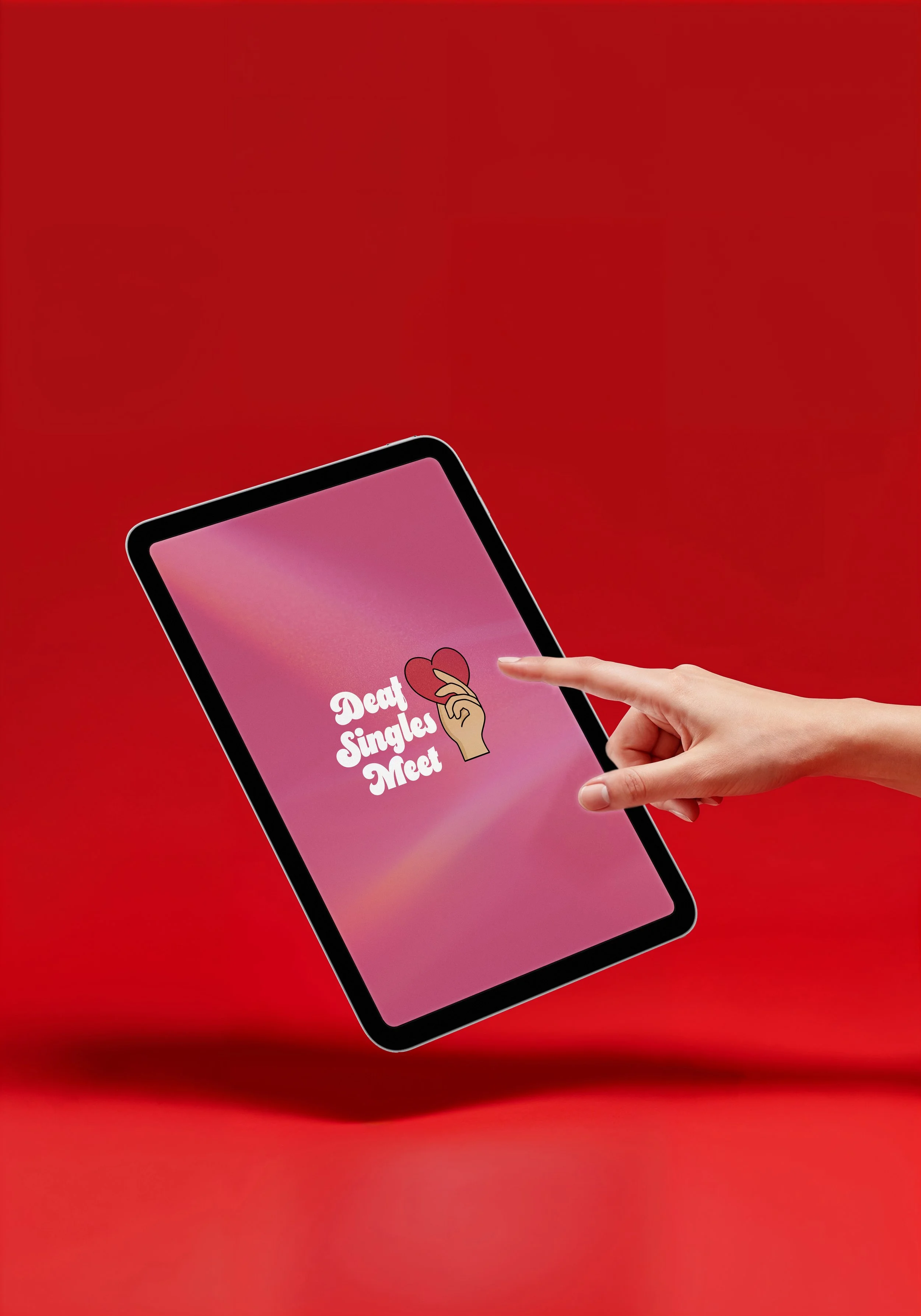 A person touching a smartphone screen displaying a dating app logo with the text 'Date Singles Meet' and a heart illustration, set against a red background.