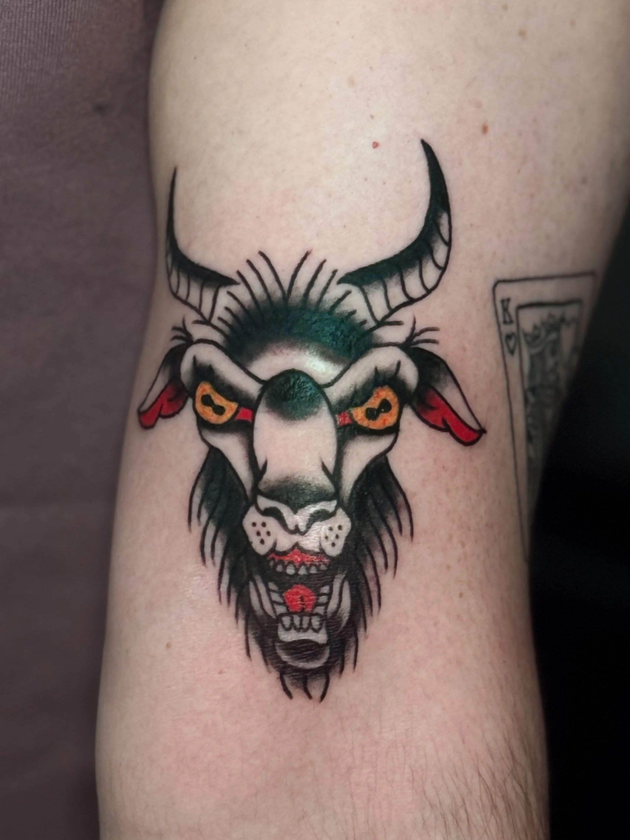 Tattoo of a lion's face with a stylized, anthropomorphic design on a person's skin.