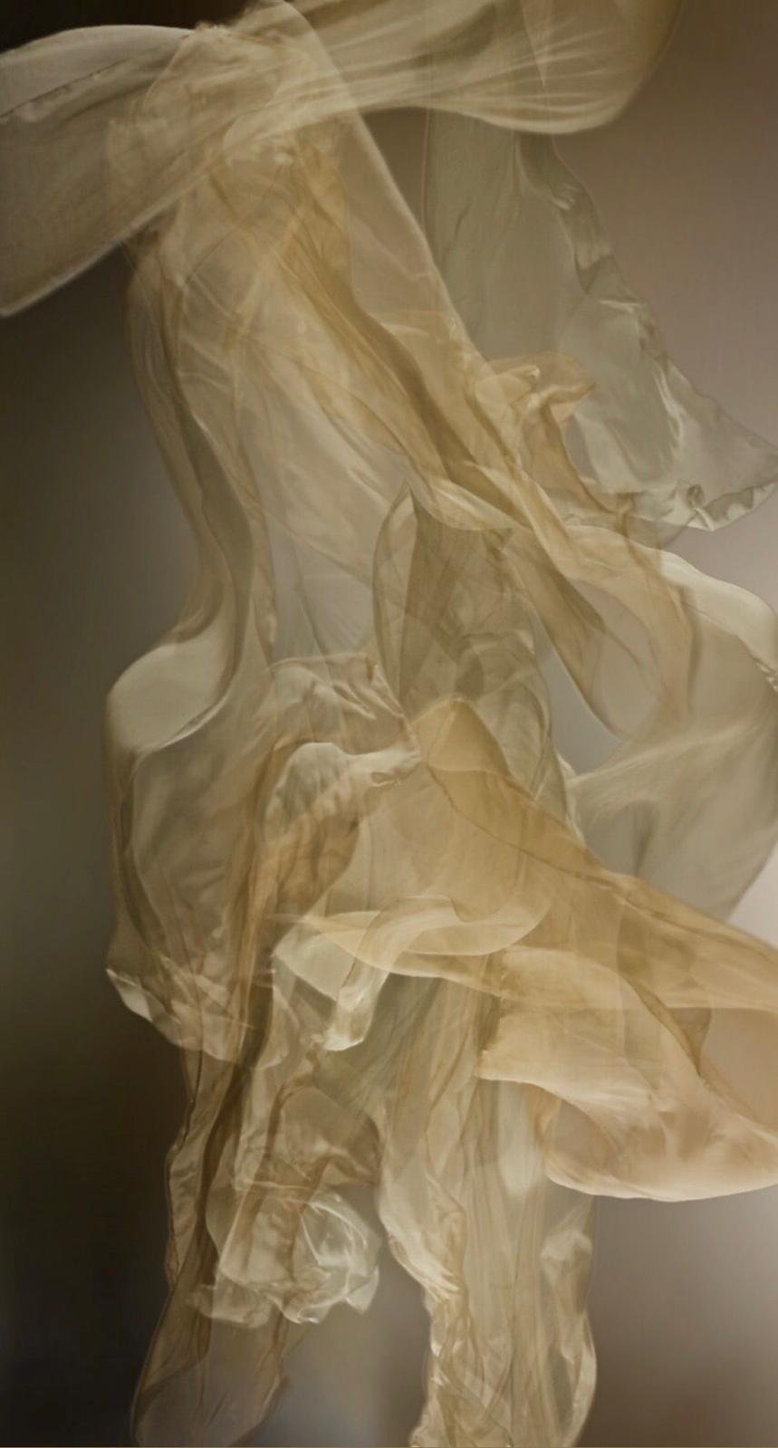 Hintergrund mit transparentem, zerknittertem Stoff in beige-hellbraunen Tönen.