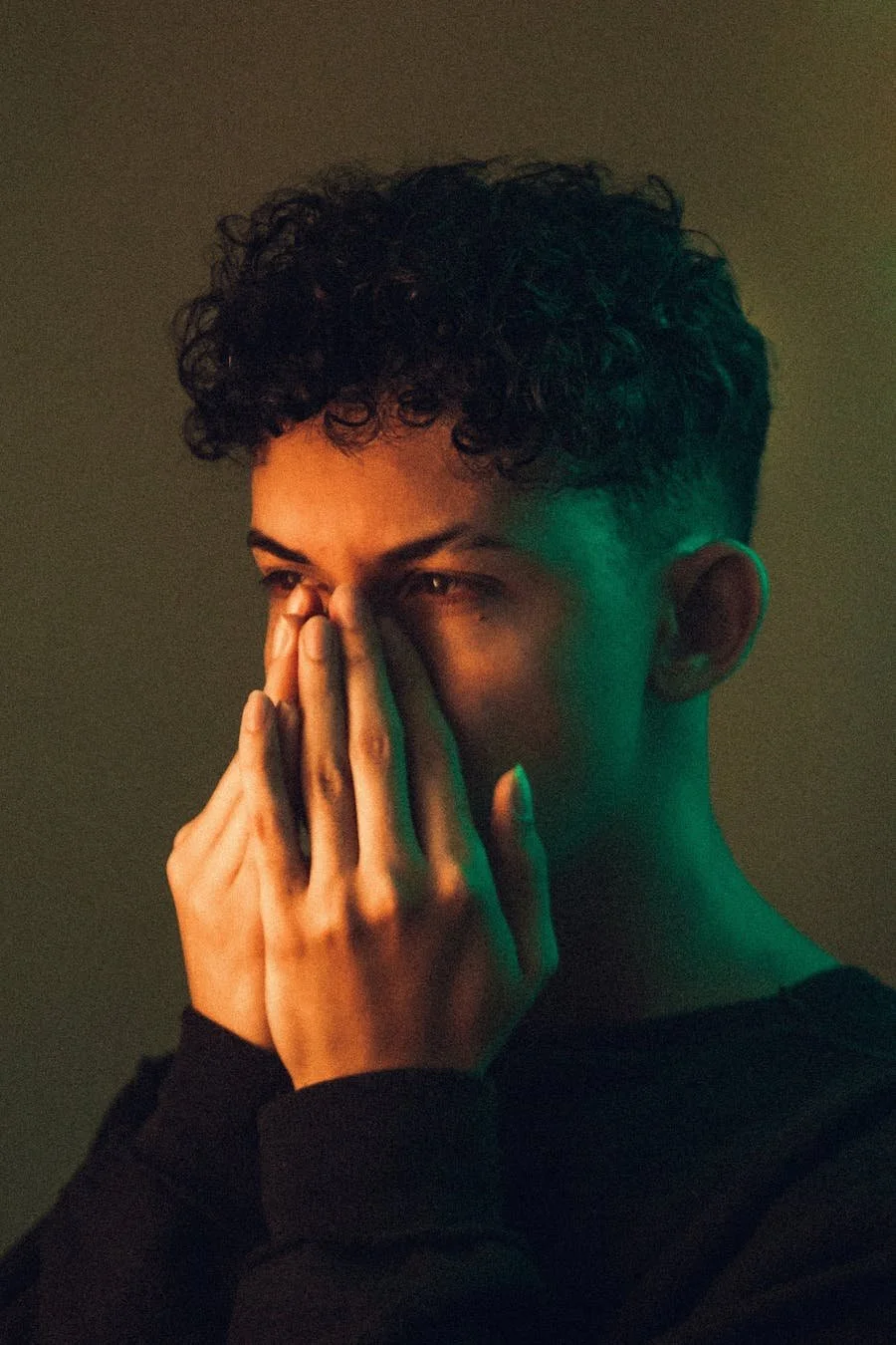 Non-binary person with their hands on their face and a look of surprise