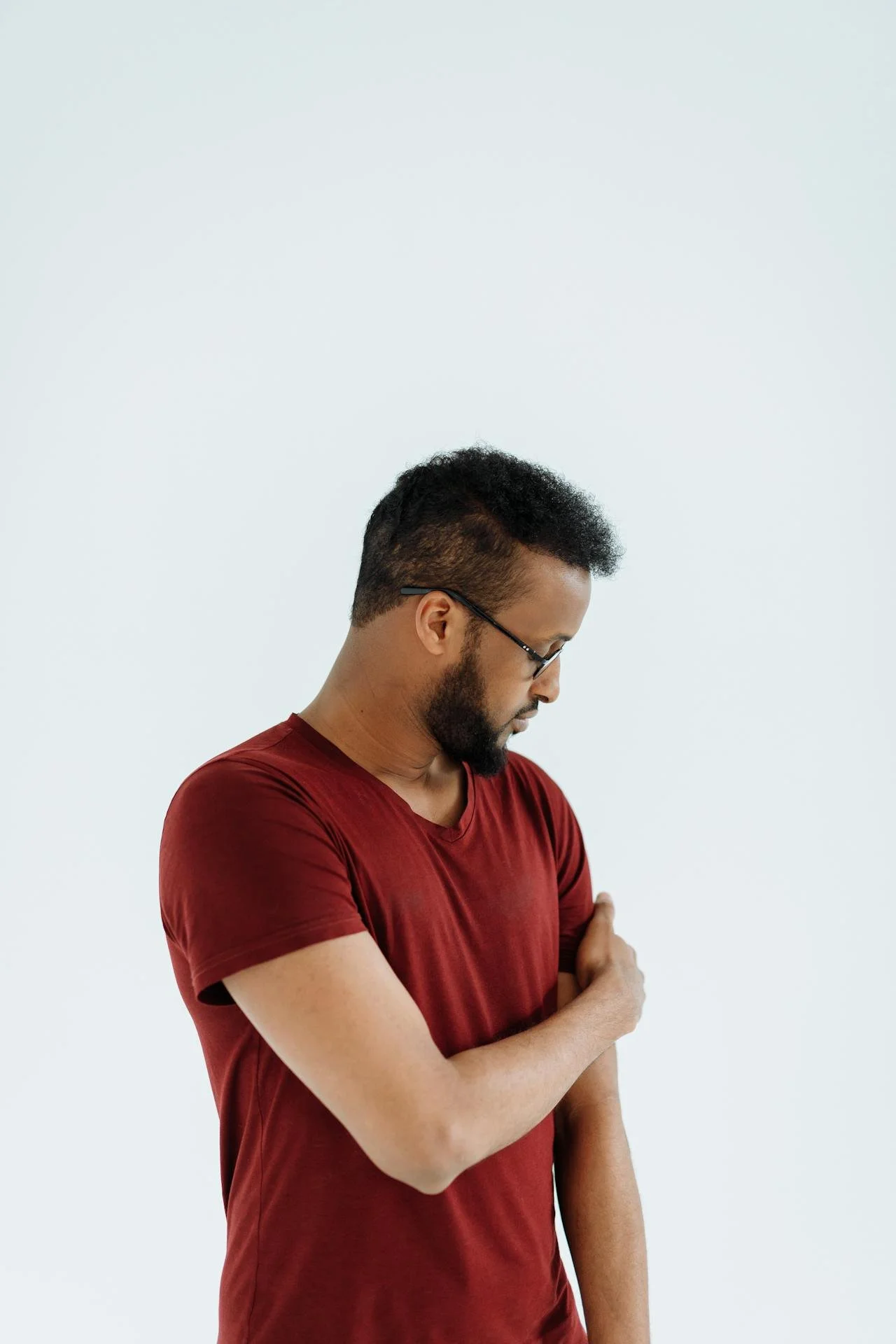 Man reaching across his body to touch his upper arm in a reassuring way