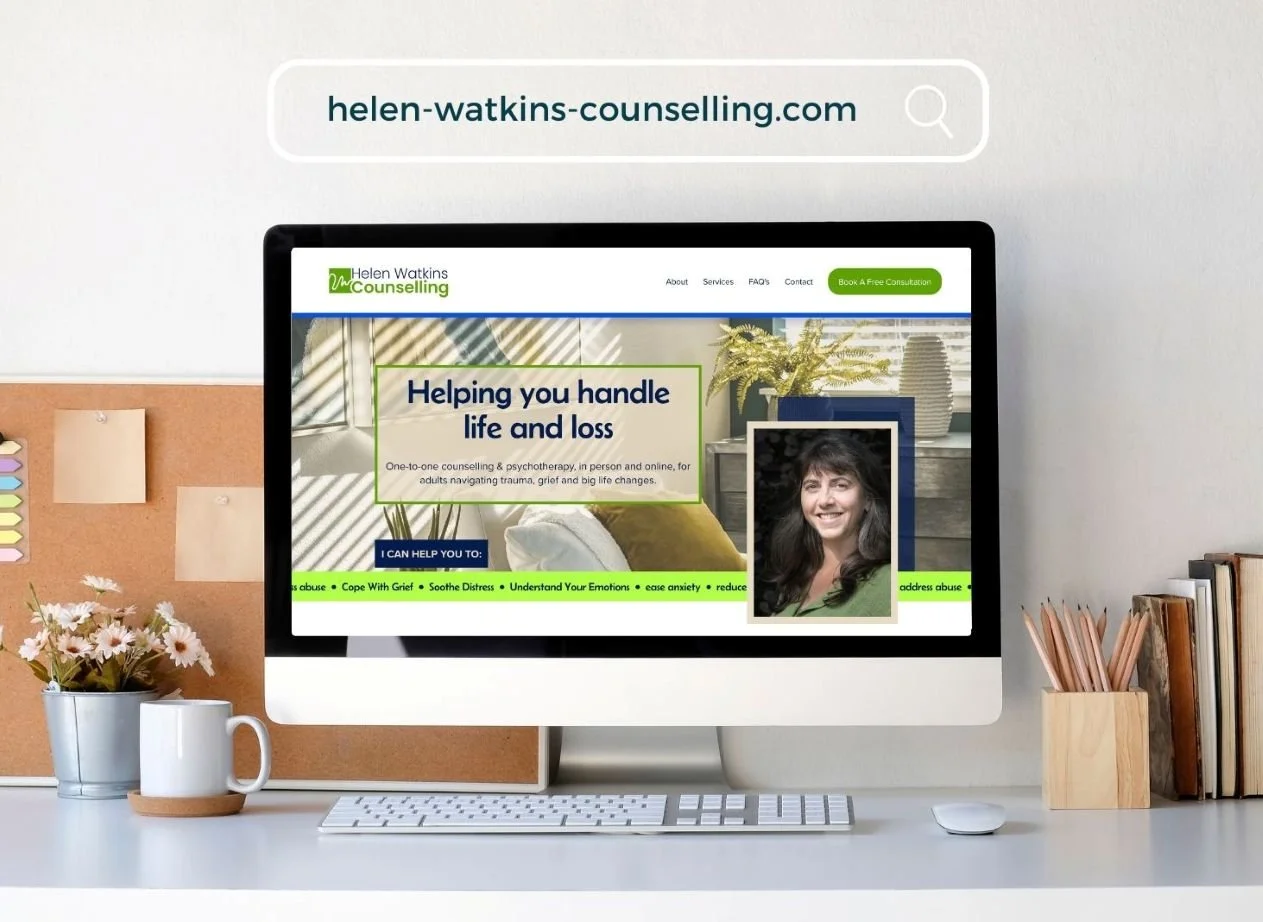 Desk with computer monitor showing homepage of Helen Watkins Counselling website