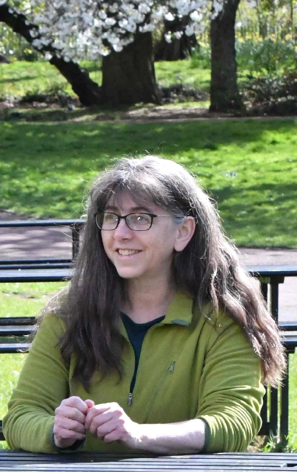 Helen sitting in a park smiling