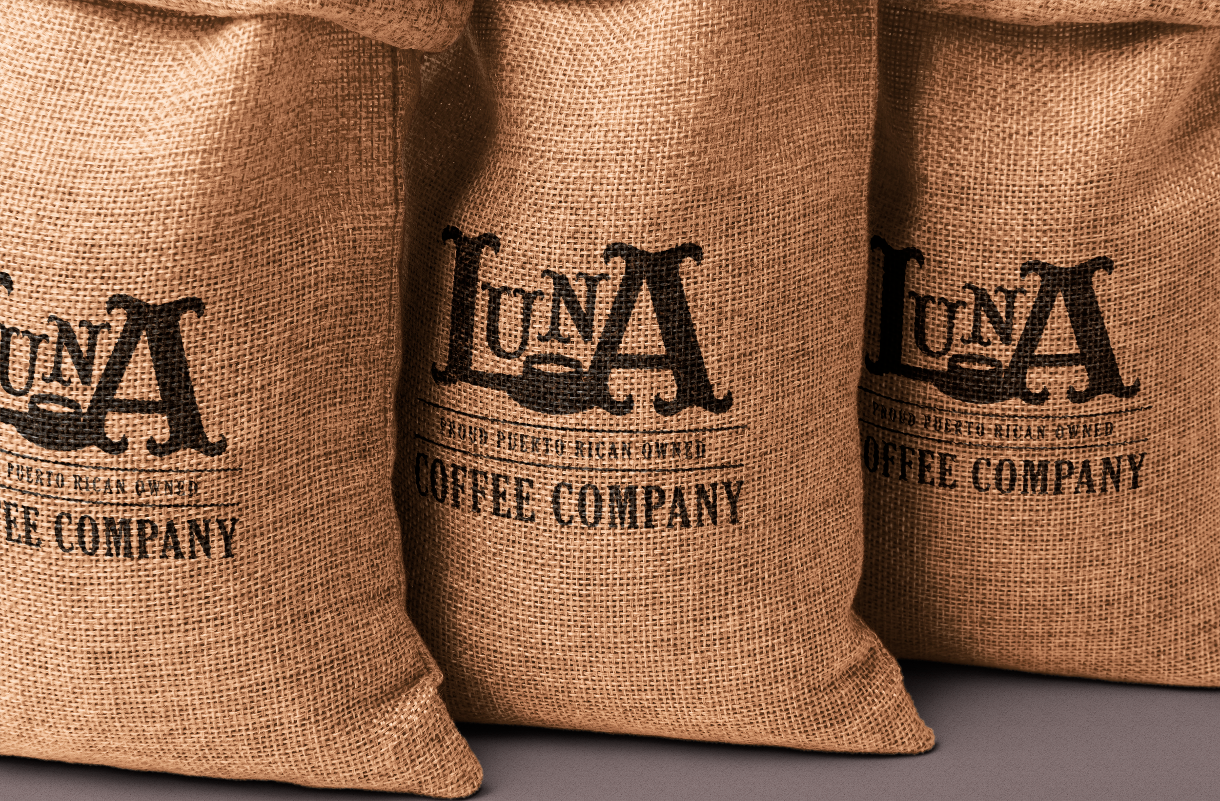 Three burlap coffee bags with black logo text for La Union Coffee Company.