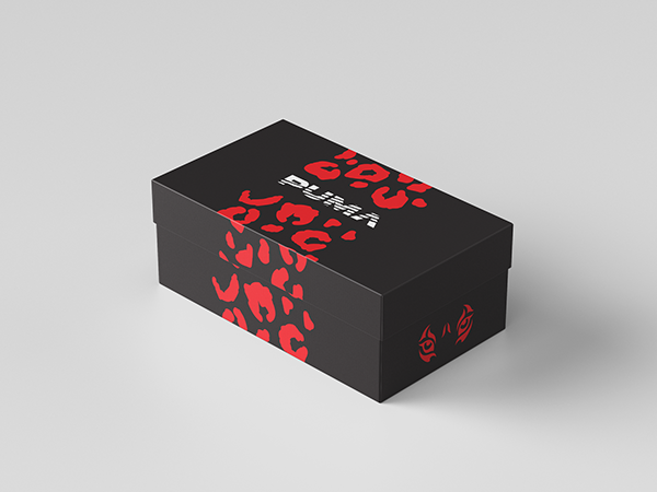 Black shoe box with red and black animal print patterns and the Puma logo, placed on a light gray surface.
