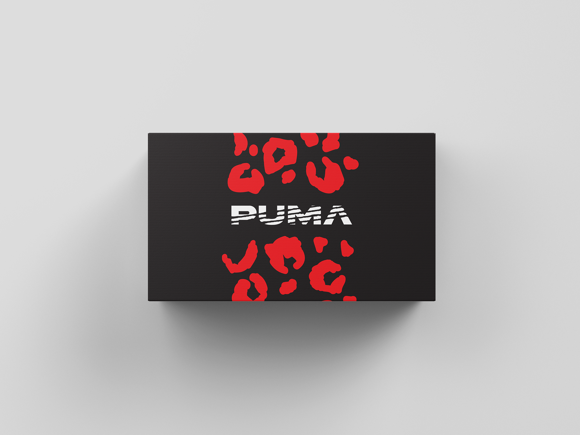 Black Puma shoebox with red leopard print pattern and white Puma logo in the center, viewed from above.
