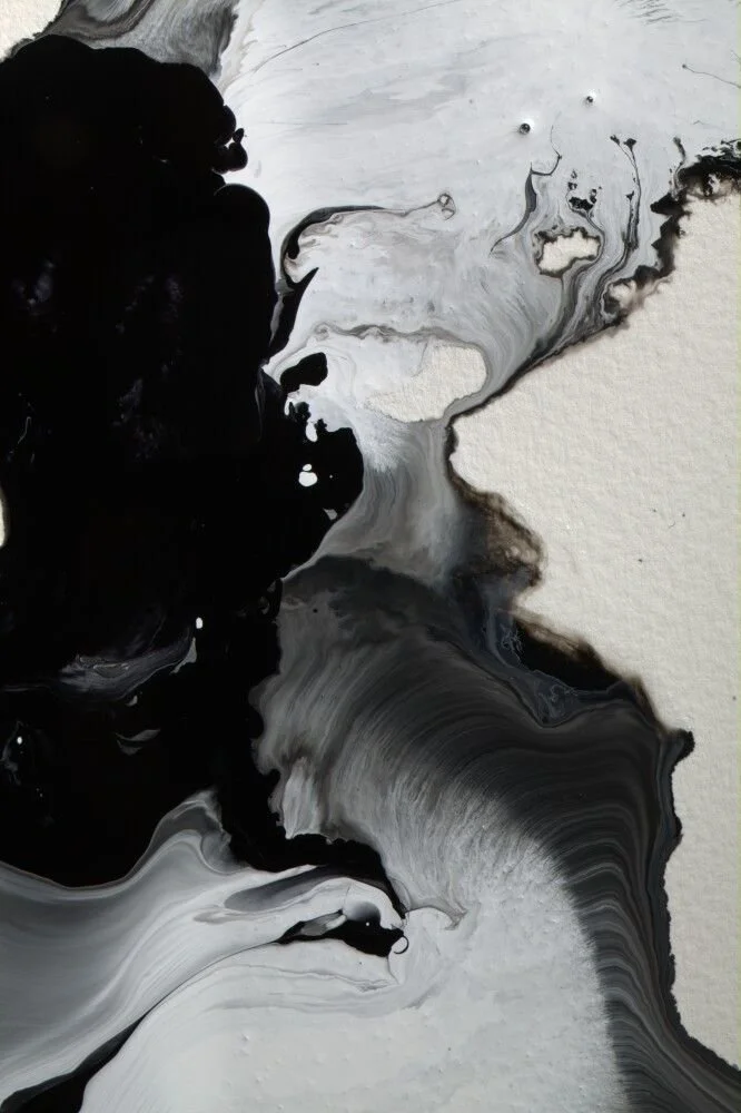Abstract black, white, and gray swirling paint on paper.