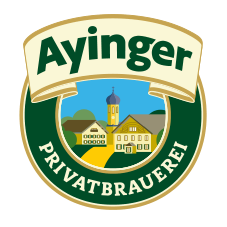 A circular logo for Ayinger Privatbrauerei featuring a scenic village with a church steeple and a building, with the brand name at the top and the brewery's name at the bottom.