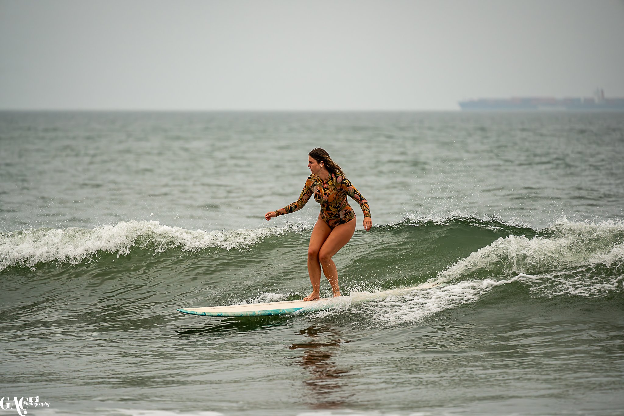 Woman surfing on small wave in ocean.