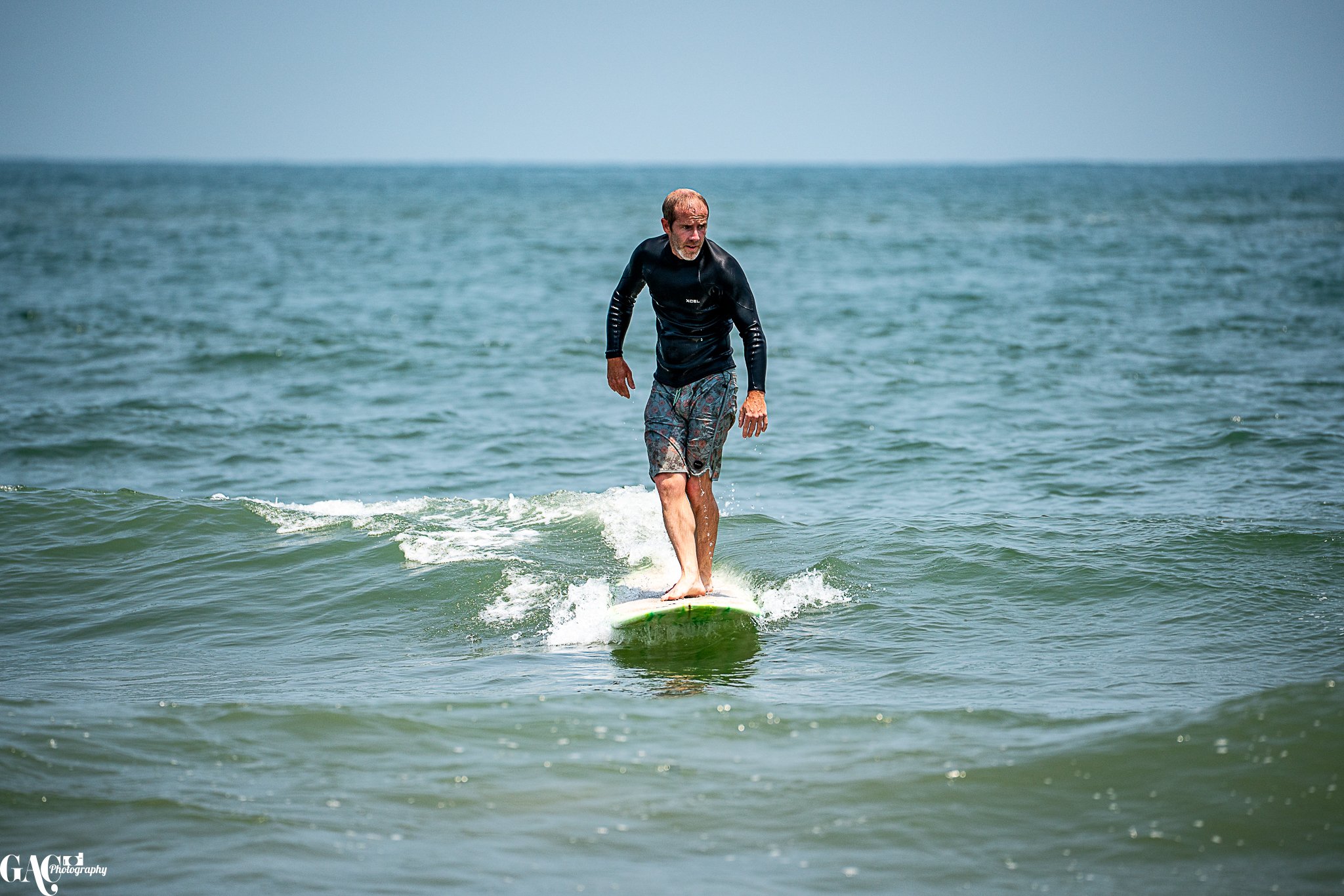 A man surfing on a small wave in the ocean during daytime.