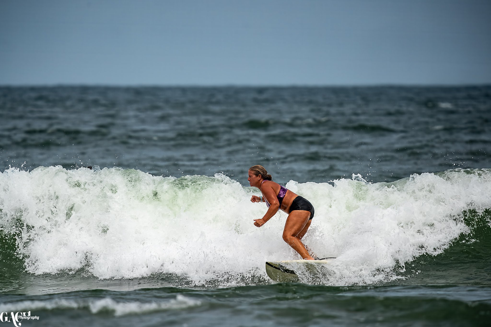A woman surfing on a wave in the ocean.