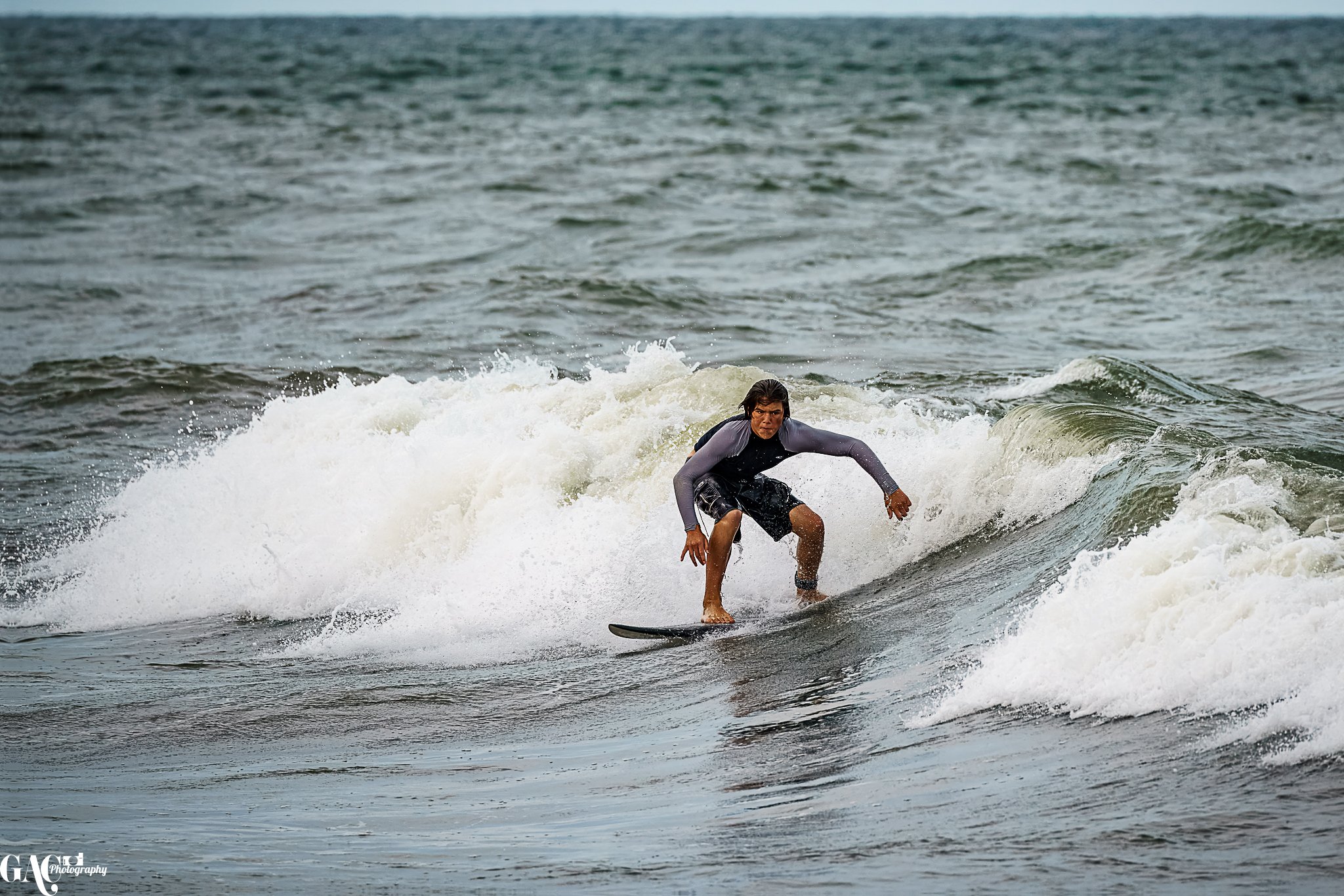 A person surfing on a small wave in the ocean