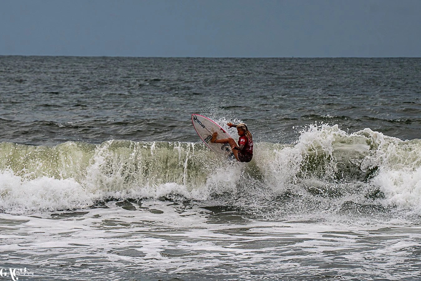 A female surfer riding a wave in the ocean.
