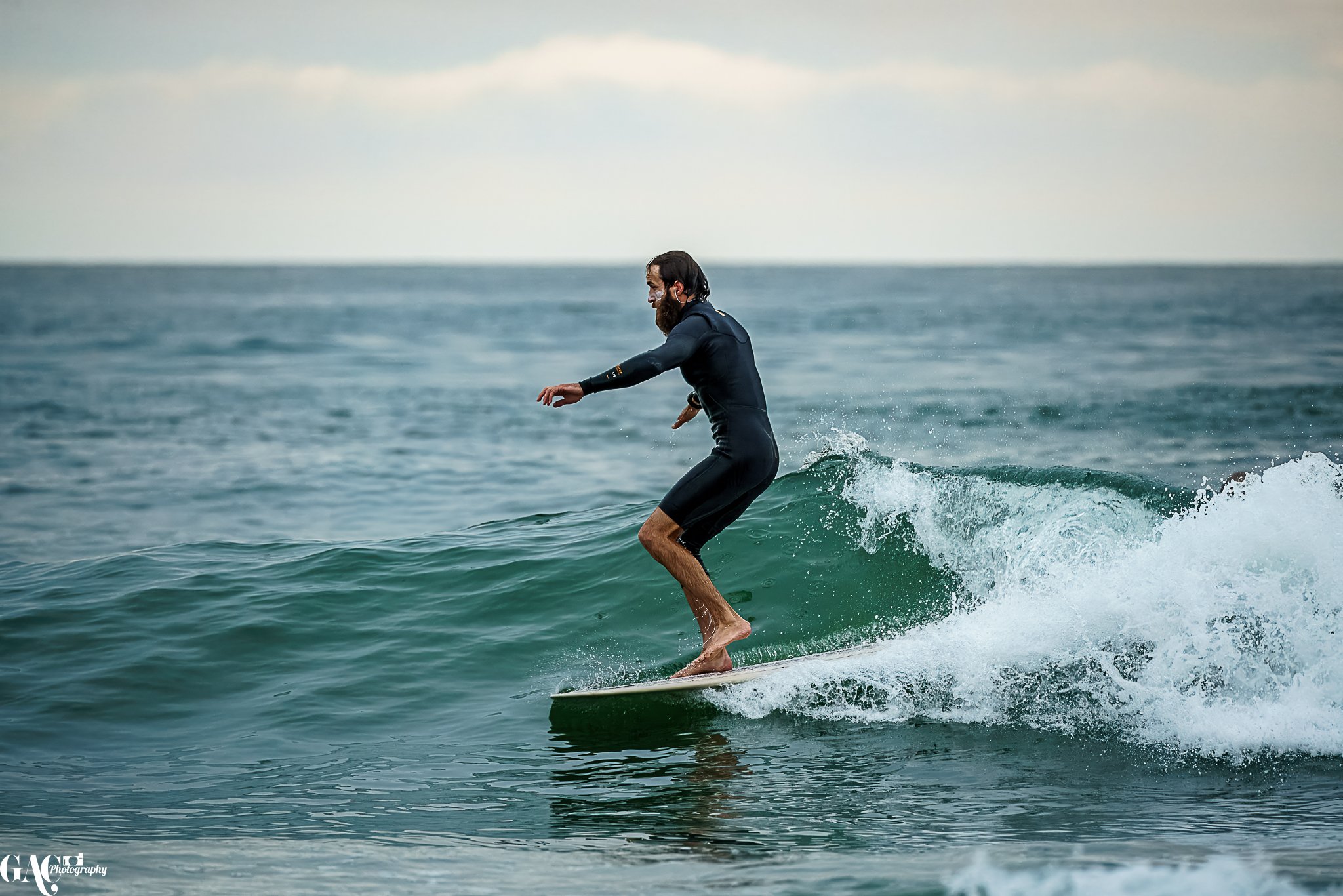 A man surfing on a small wave in the ocean.