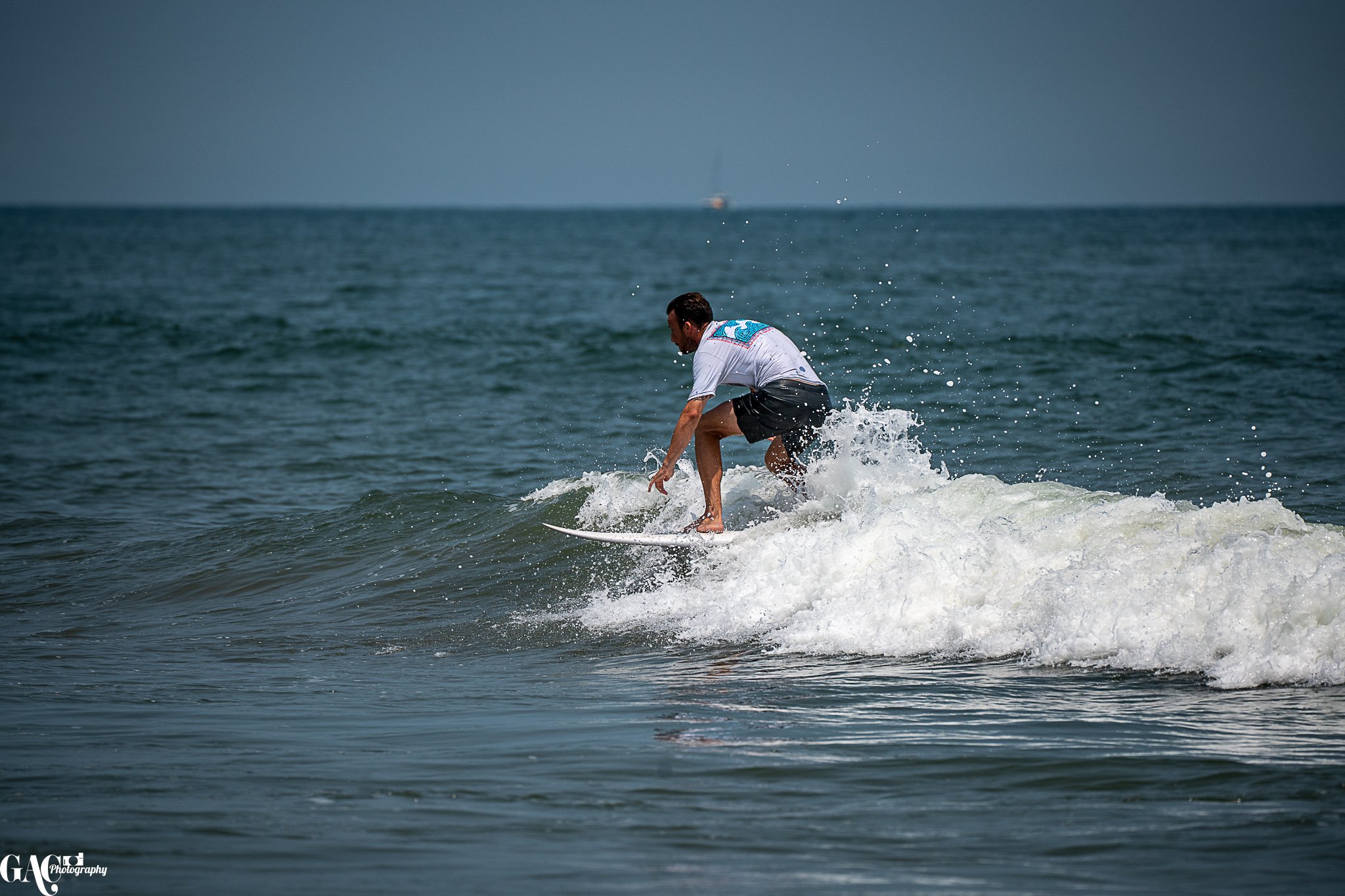 A man surfing on a small wave in the ocean.