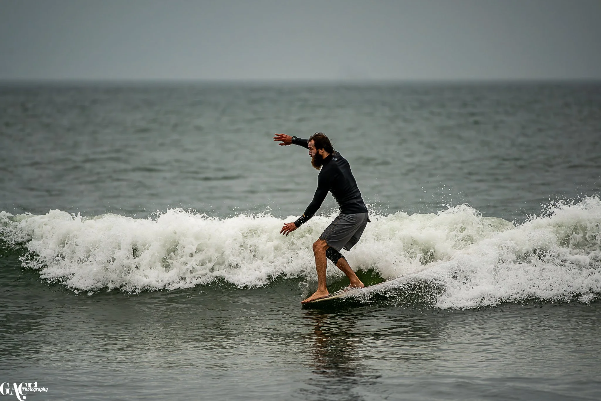 A man surfing on a small wave in the ocean.
