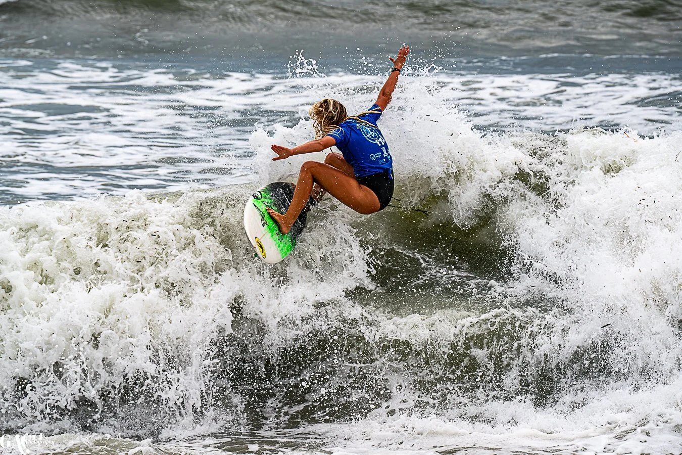 Person surfing on a wave with a surfboard in the ocean.