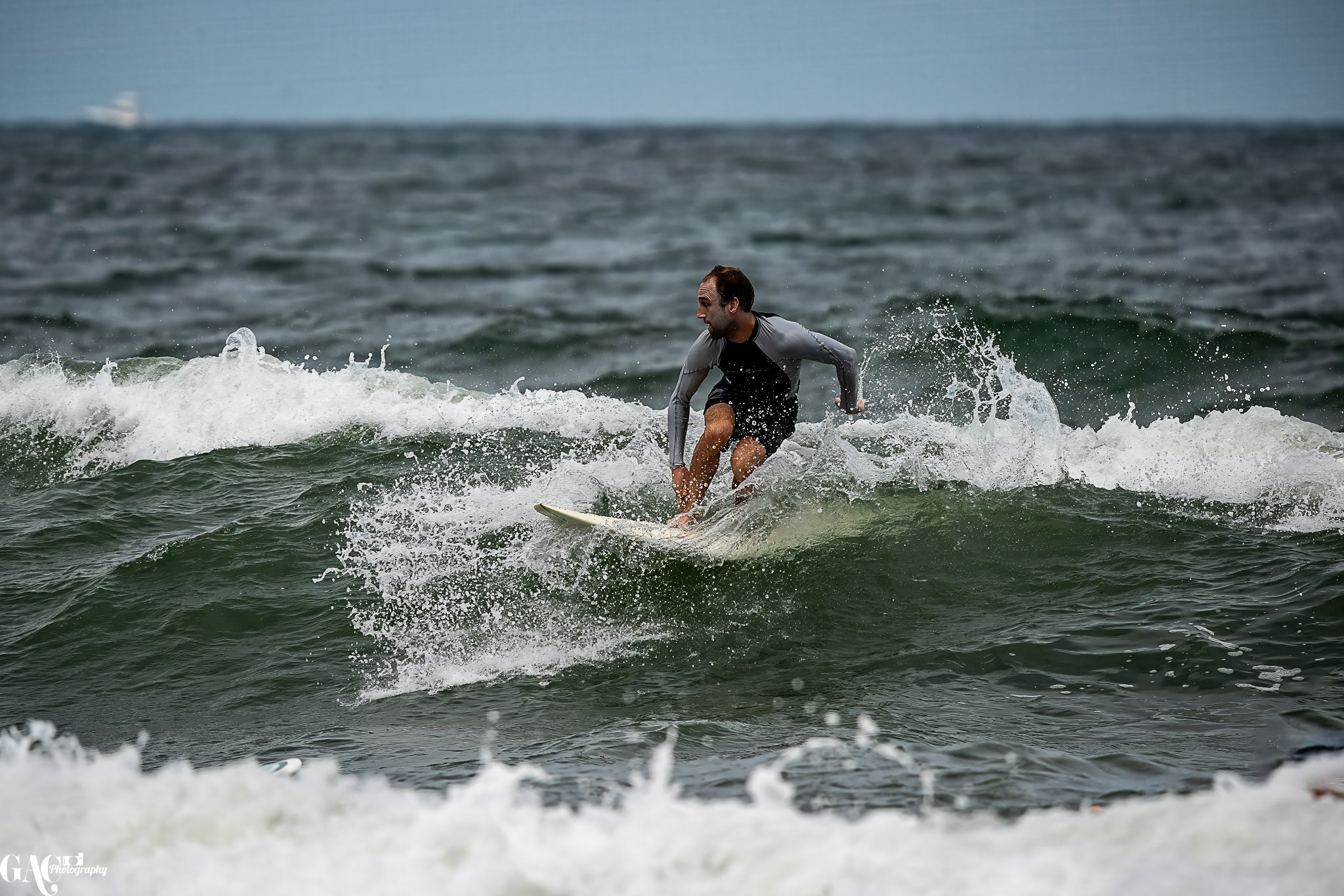 Man surfing on a wave in the ocean.