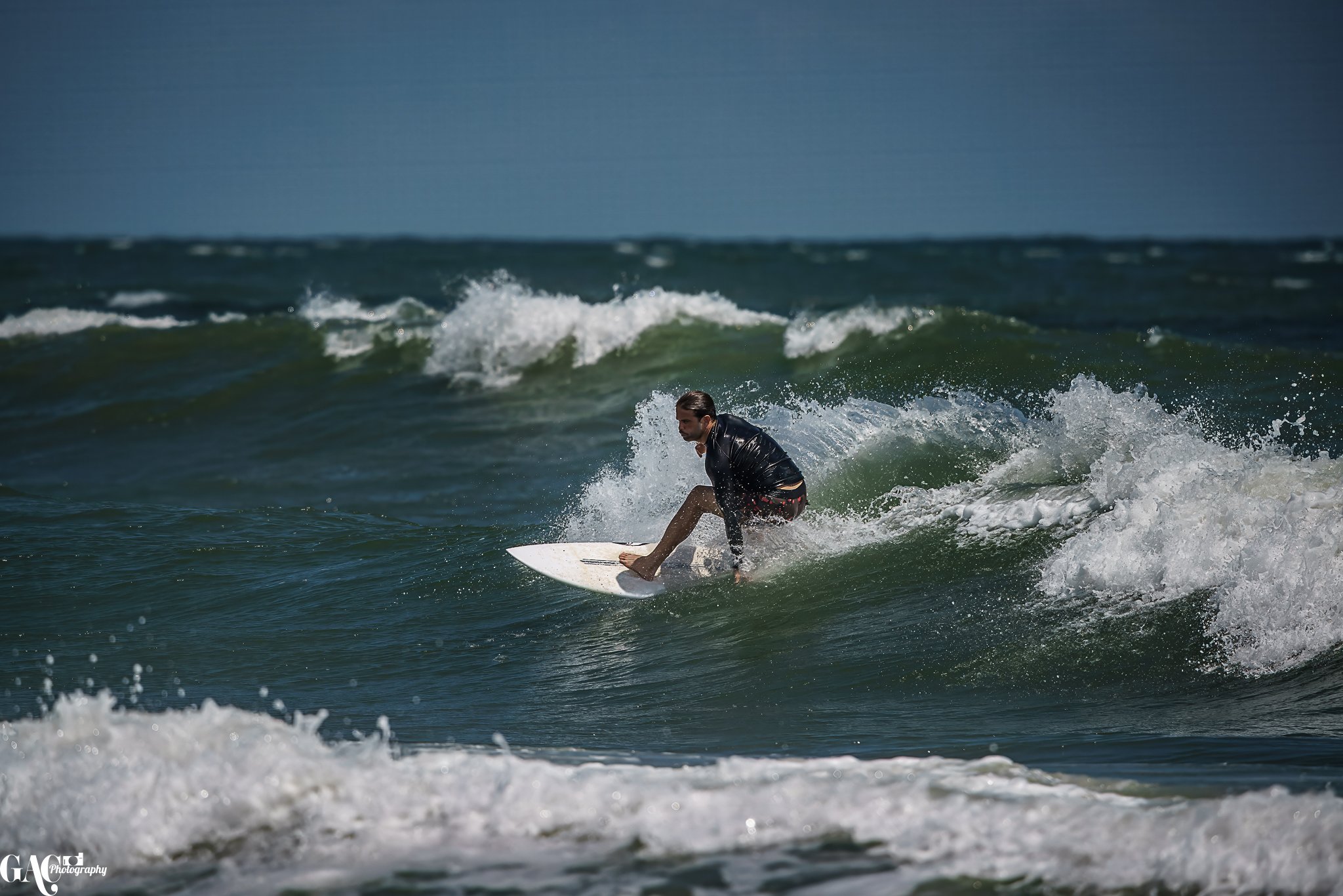 Man surfing on a wave in the ocean.