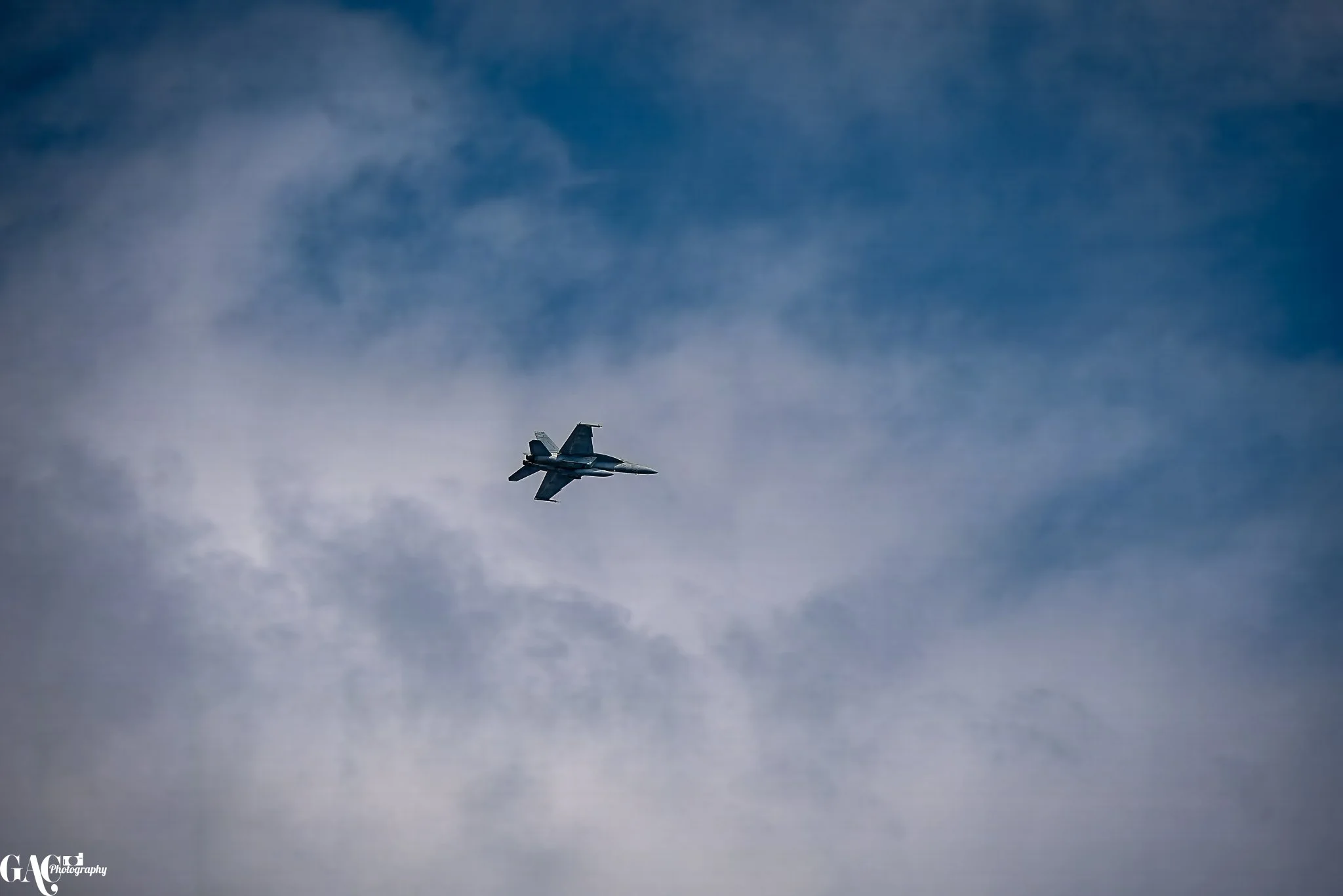 A fighter jet flying through a cloudy sky.