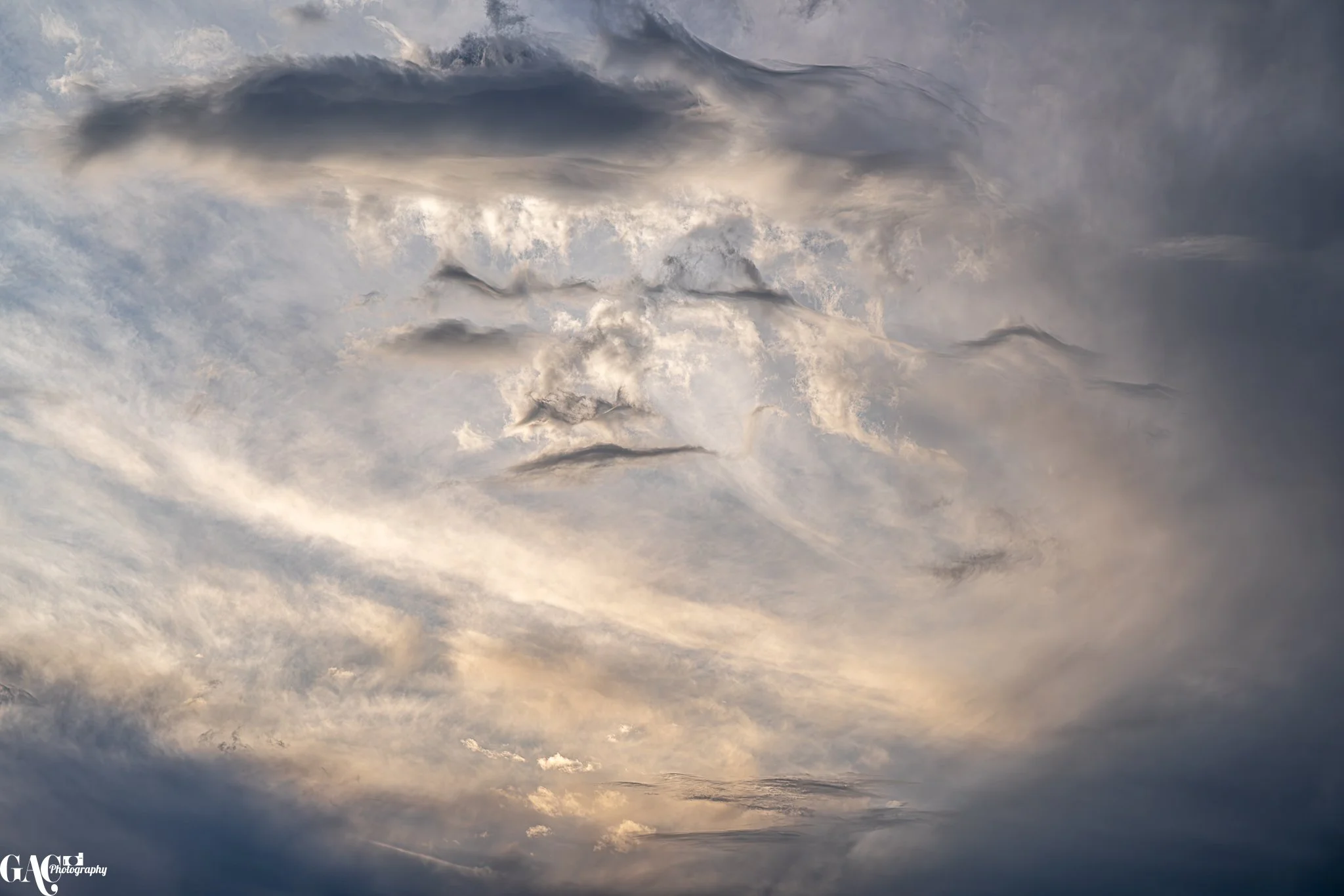 Dramatic sky with swirling clouds and soft light tones.