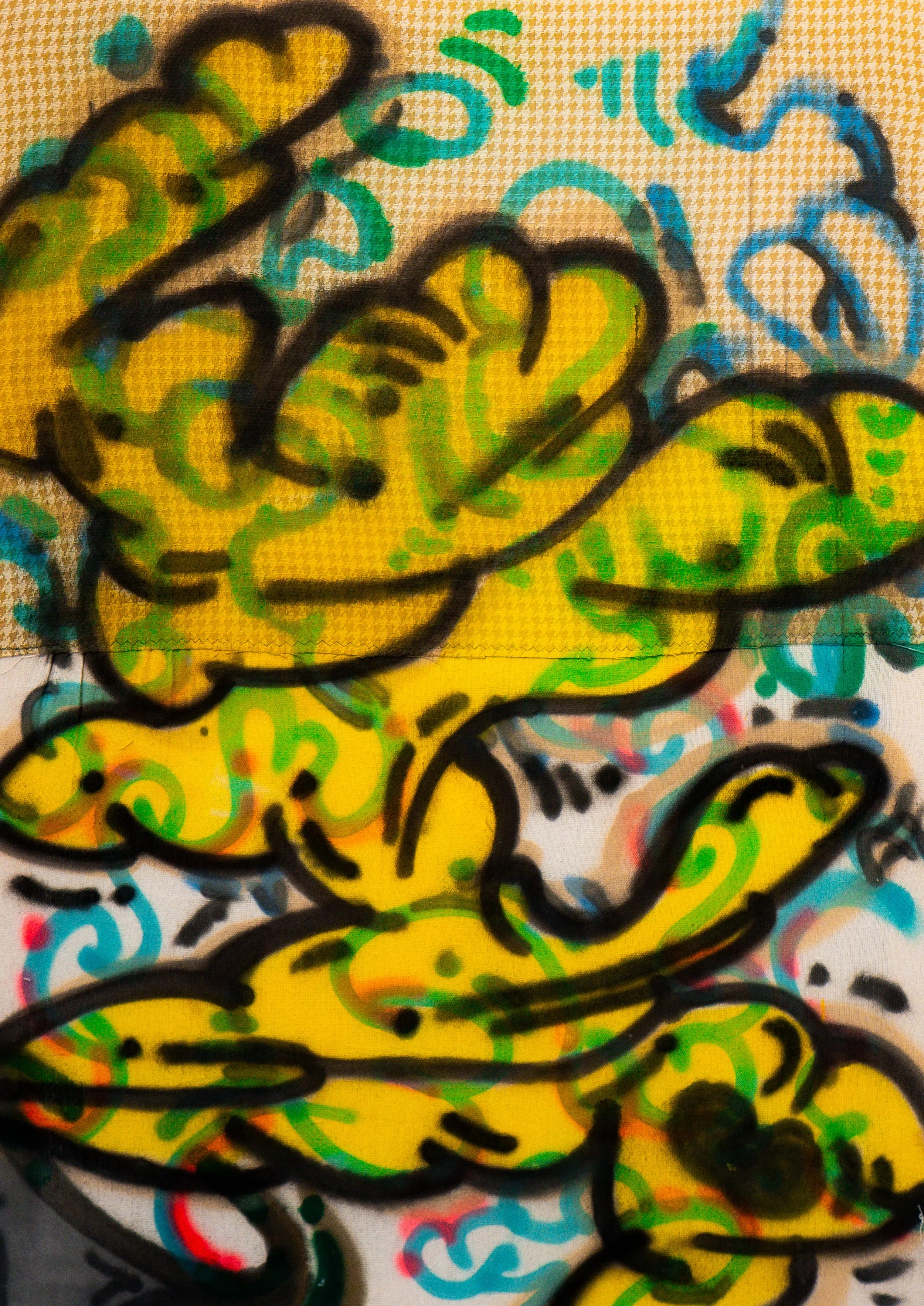 Colorful abstract drawing with yellow, green, blue, red, and black markers, featuring various swirling and curving lines.