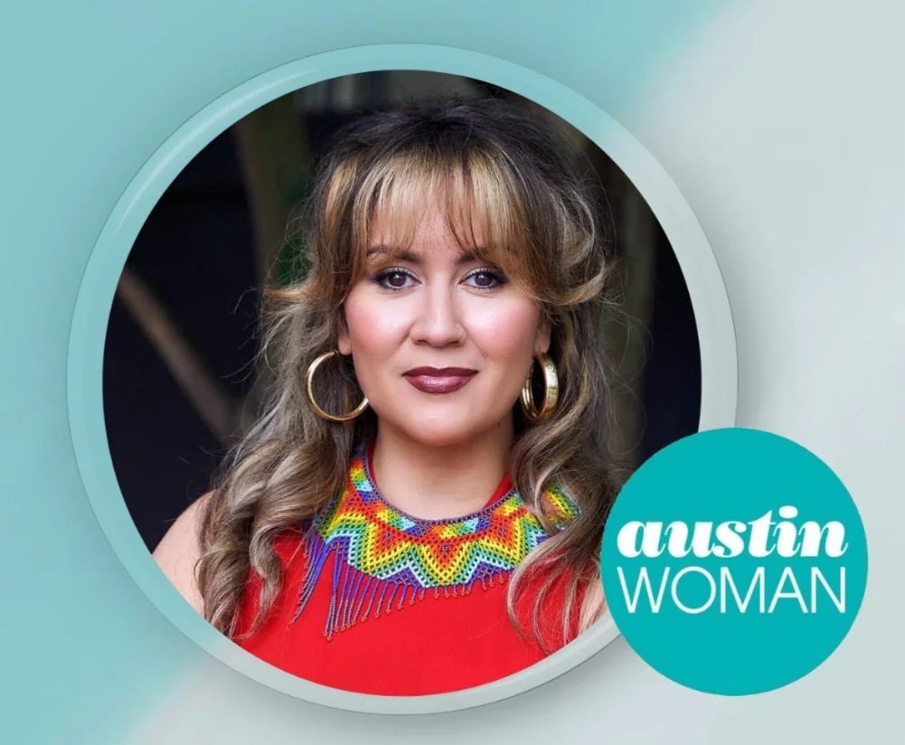 A woman with wavy brown hair and hoop earrings, wearing a colorful beaded necklace and a red top, is looking at the camera. The image includes a circular logo that says "Austin Woman."