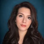 A young woman with long dark hair, wearing makeup, and a neutral expression.