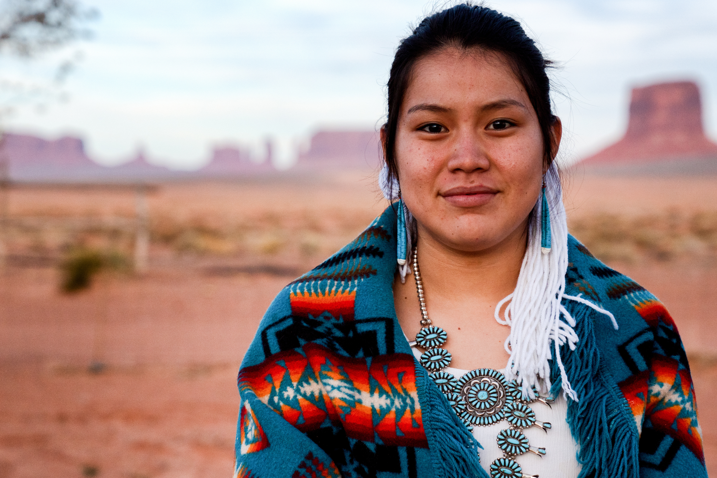 Native American woman standing in front of a picturesque desert landscape