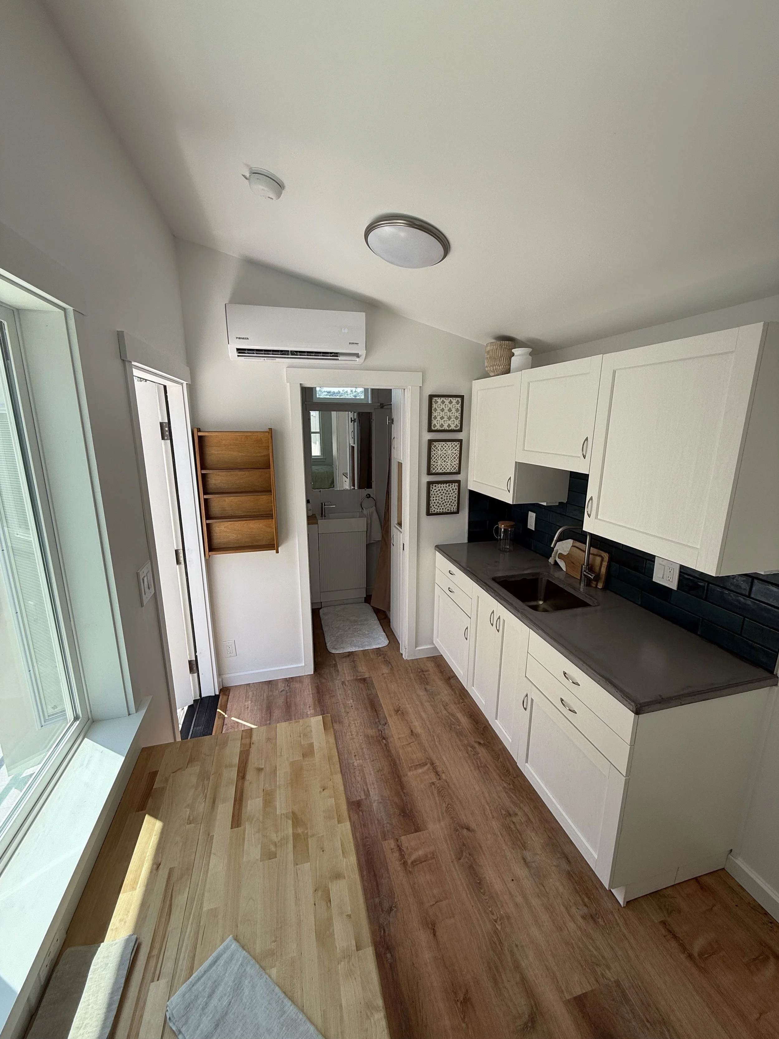 Concrete counter,
Stainless steel sink,
Apartment sized refrigerator, and
Lots of cabinet space